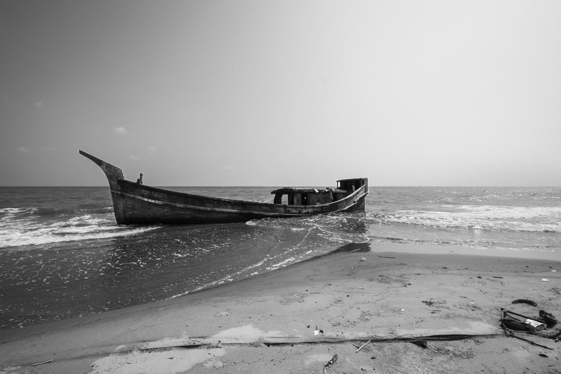 A boat used by Rohingya refugees to flee from Myanmar. The Rohingya have been persecuted for many years in their homeland making them flee for safety and survival to Bangladesh, Malaysia and now Indonesia as boat people spending several weeks at sea on unworthy boats at the peril of their lives. Pidie shore, temporary shelter, Aceh, Indonesia, February 2024
