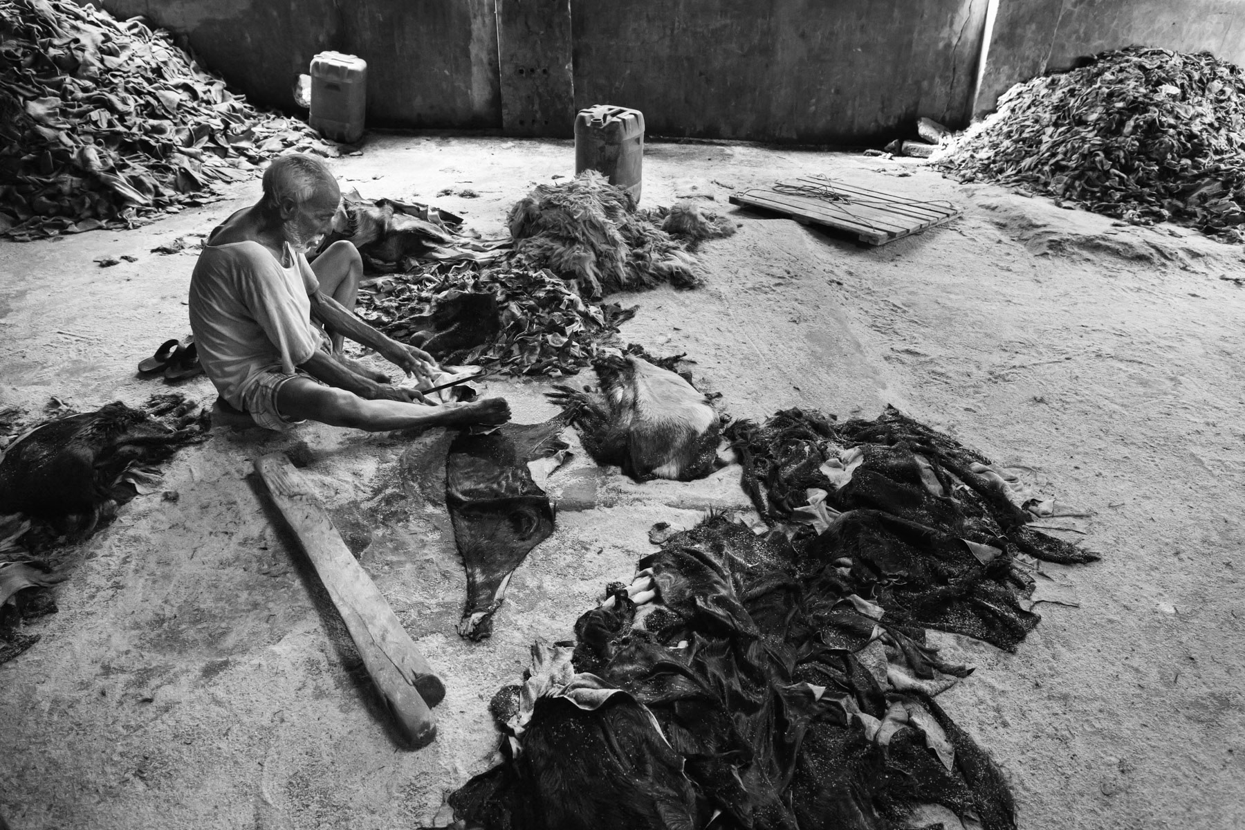 Tannery worker cutting the edges before the skins are being processed, Chittagong, Bangladesh, May 2015