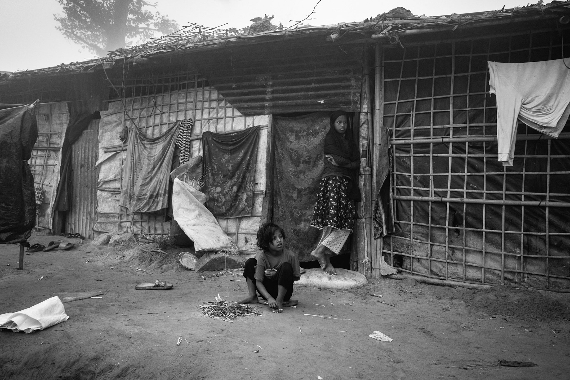 A young child sits outside a shelter in Balukhali camp 9, Cox's Bazar, Bangladesh, January 2026