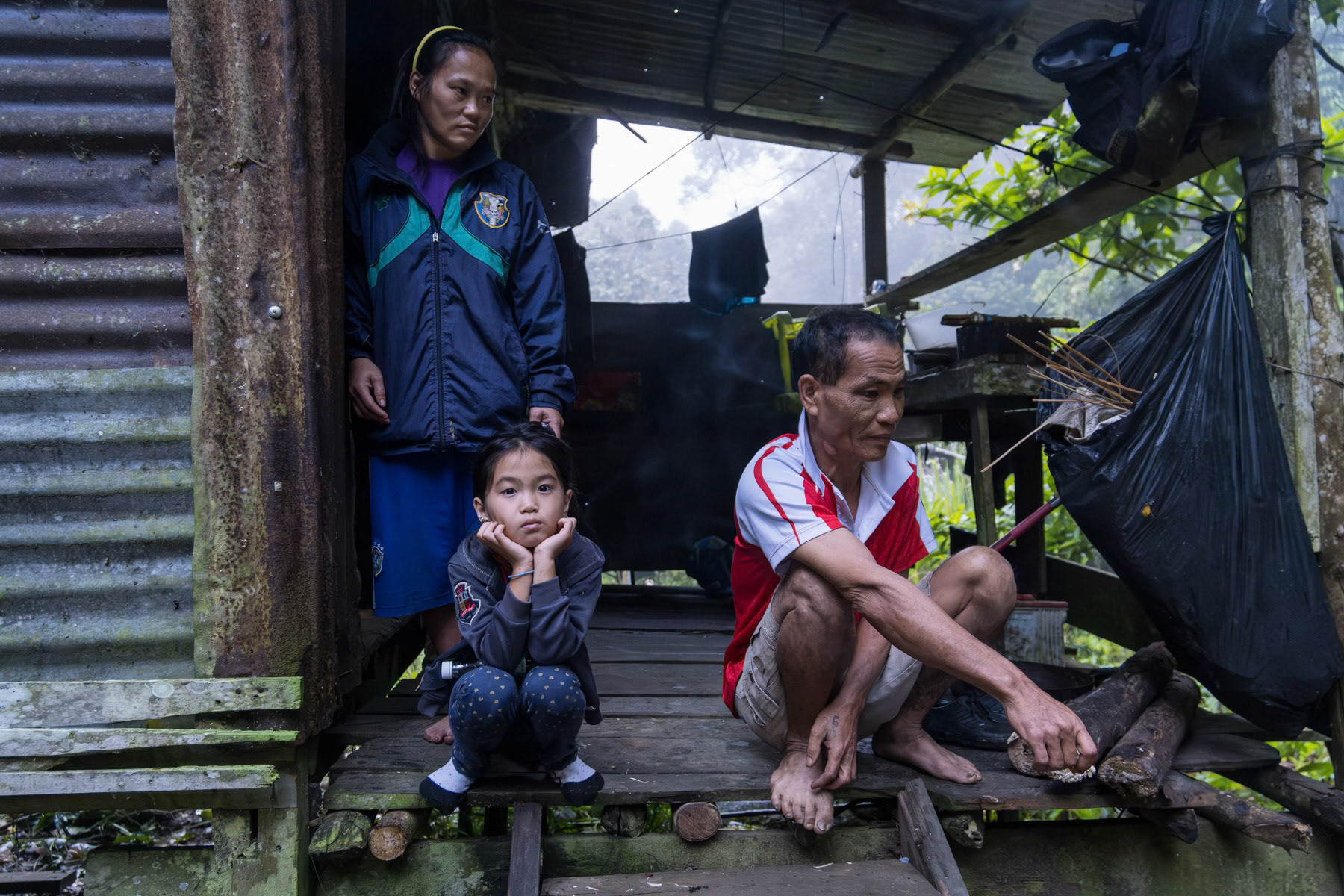 A family of the Penan tribe, an indigenous community living partly on the edge of the rainforest. During long periods the whole community also moves inside the forest to hunt, fish and collect fruit. Penan settlement, Bario, Sarawak, Borneo, Malaysia, October 2023