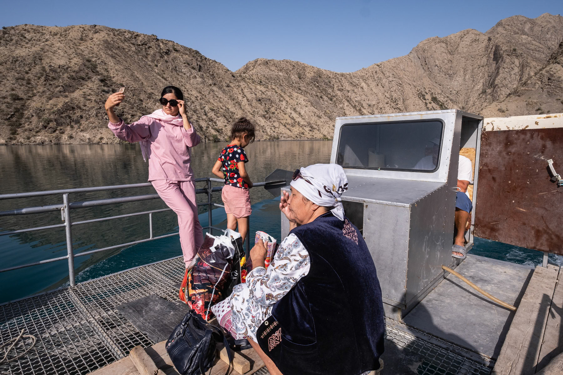 People crossing the Naryn river in Kyzyl Beyzit after visiting relatives. Kyzyl Beyzit is and area that has been flooded since the eighties when dams were constructed on the Naryn River. The remaining village is locked in and only accessible by boat and donkey or horse accross the river. About 300 people live there. The hydro electrical power station on the Naryn river and the Toktogul reservoir are crucial for Kyrgyzstan's energy needs, but with longer and recurring periods of drought it becomes impossible to cater for an ever increasing population. The Naryn river, which in Uzbekistan will become the Syr Daria river and eventually flow into the Aral Sea, has an ever decreasing volume. Further accelerating the complete disappearance of the Aral Sea few thousand km away. Kyzyl Beyzit, Jalalabad region, Kyrgyzstan, August 2021