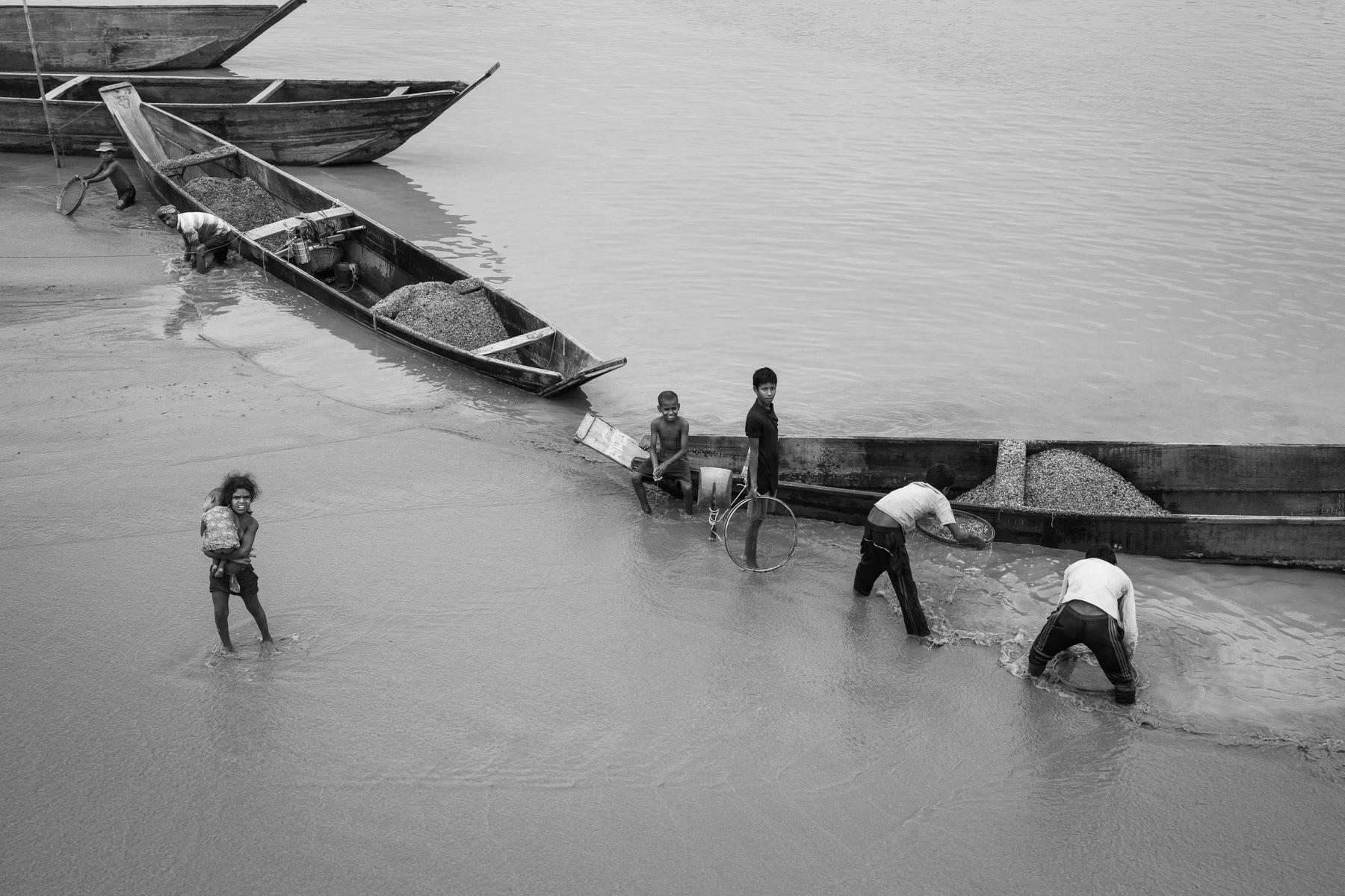 Stone divers sorting stones that will later be used to supply the booming construction sector. Dholai river in Bholaganj, Bangladesh, May 2016