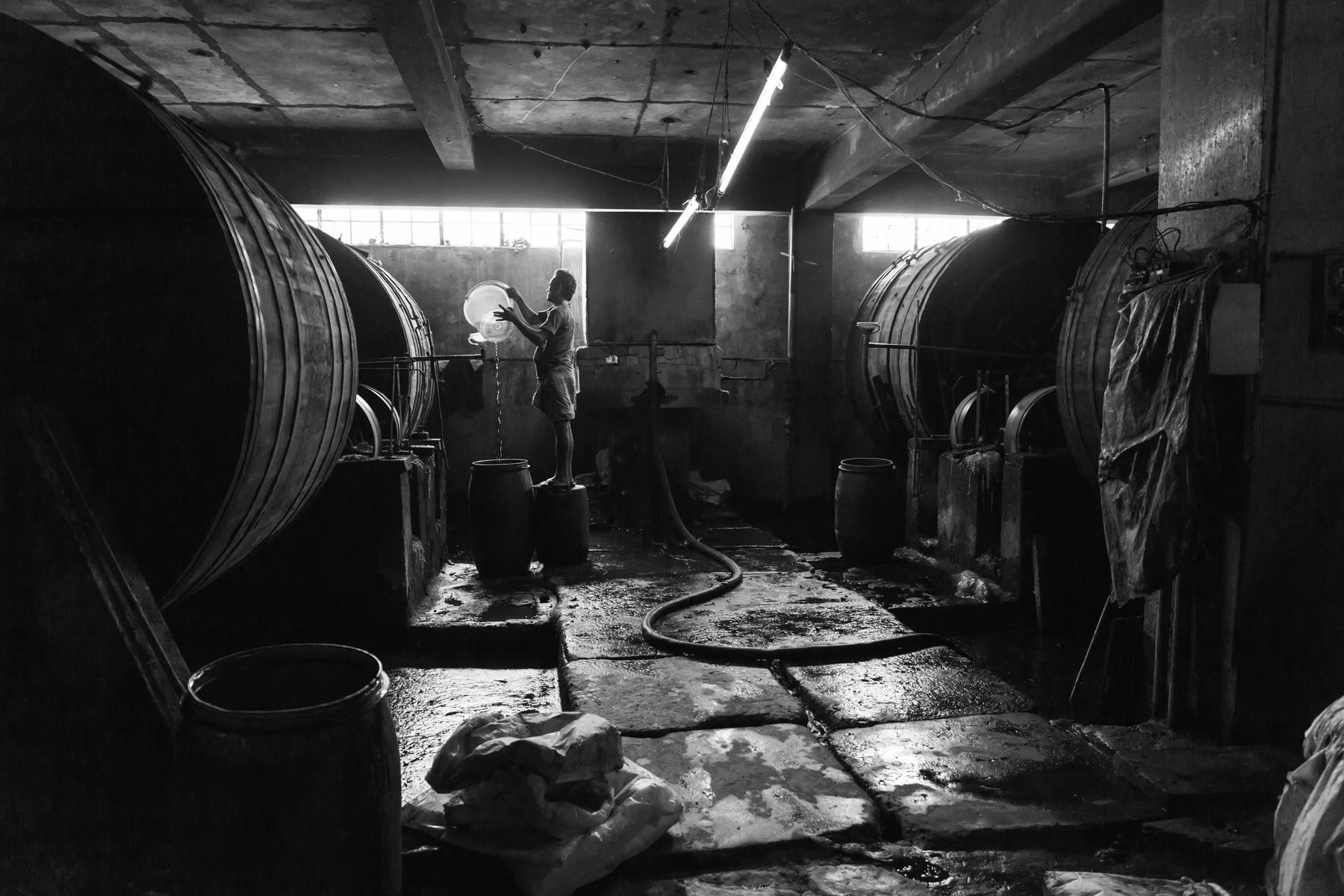 Tannery worker mixing chemicals before raw skins are put in the process drums. Hazaribagh tannery, Dhaka, Bangladesh, May 2015