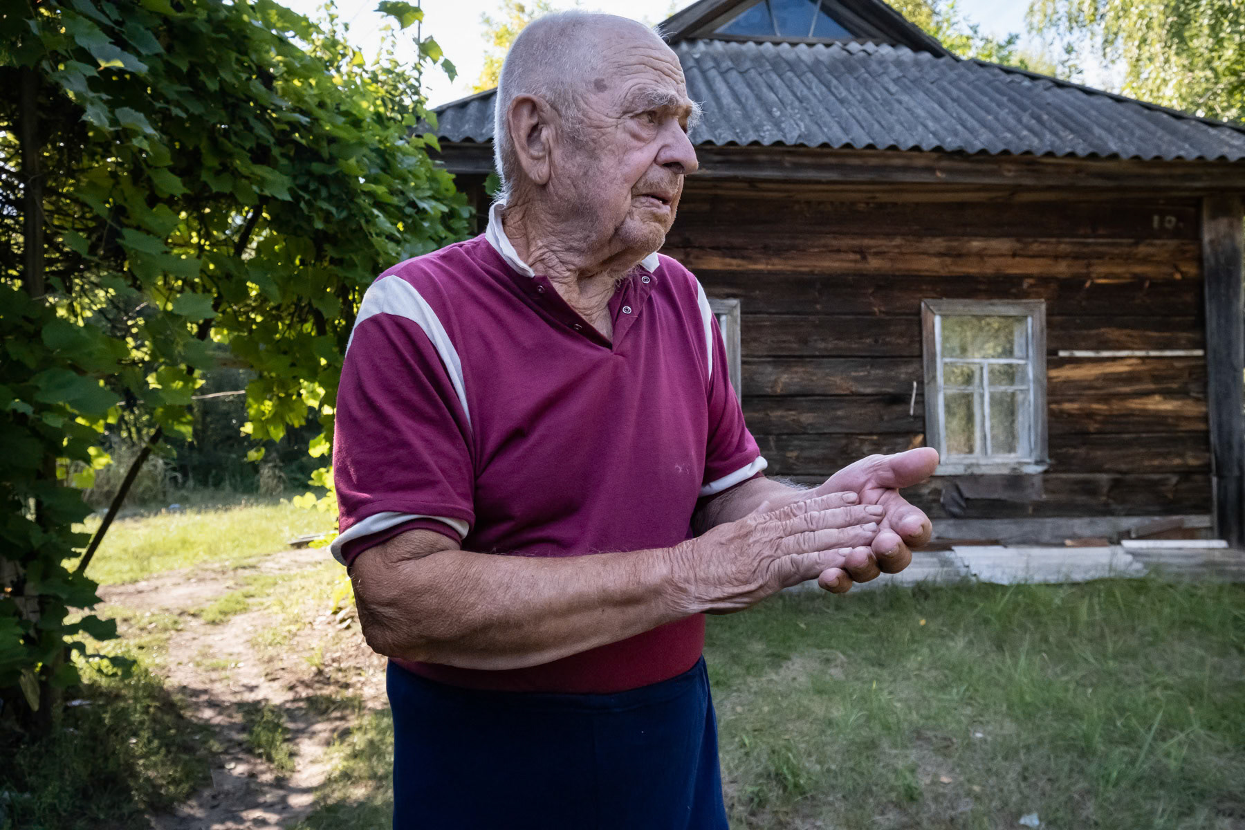 Kuzmich, 87 years, from Teremtsi village in the exclusion zone, is a survivor of World War II when as a 7 years old boy the village was burned by the Nazi. Has always lived in Teremtsi, even after the nuclear accident he came back immediately after the evacuation by boat. He lives alone, stays there all year. Only 10 people live in the village and the closest town with basic medical facilities is one hour driving away. Teremtsi, Chernobyl exclusion zone, Ukraine, August 2021