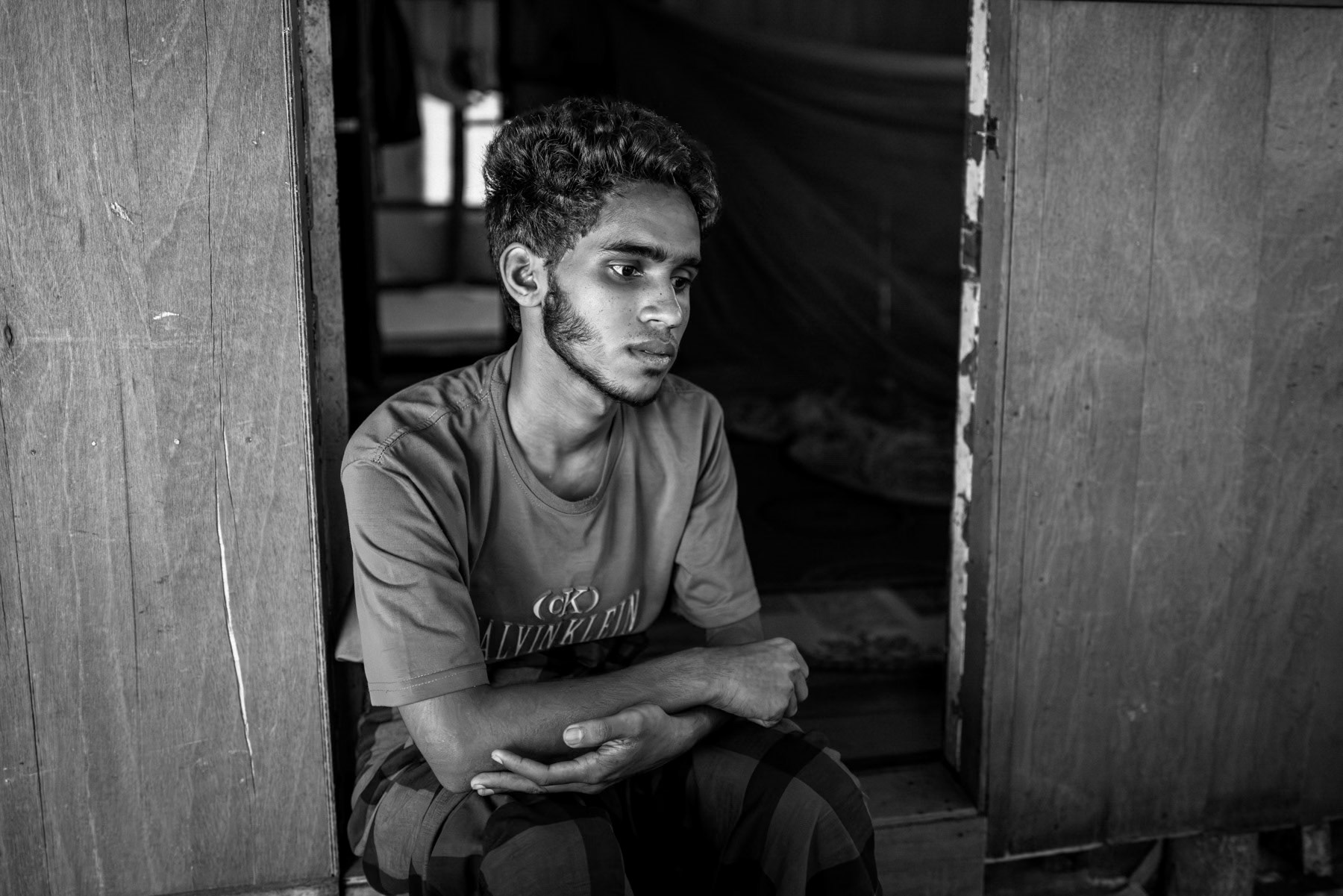 Eighteen-year-old Zani Alam, from Taung Bazar in Buthidaung, fled to Bangladesh with his family in 2017. He was kidnapped from Bukhali camp on 29 September 2025 and held in captivity in the Teknaf area before being sold to another trafficker operating between Indonesia and Malaysia. After three days in custody, he was transported by boat with around 300 others on a ten-day journey to Dumai, a key trafficking hub used to funnel Rohingya refugees into Malaysia for resale. In Dumai, traffickers beat him with metal rods—mainly on his arm—when he refused to continue to Malaysia and demanded he repay the cost of the voyage, about 4,000 USD. Four days ago, he escaped at around 4 a.m., hid until daylight, and, with help from local residents, reached a police station. Authorities transferred him to Pekanbaru, from where he arrived at the camp on 21 October 2025. Rohingya refugee camp in Pekanbaru, Indonesia, October 2025