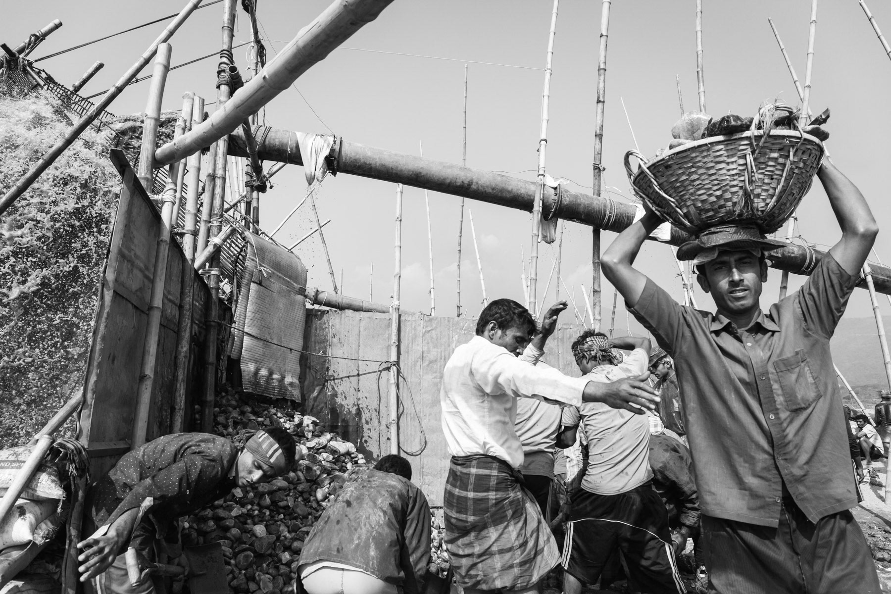 Stone carriers under an extraction pump in the Dholai river in Bholaganj, Bangladesh, December 2015