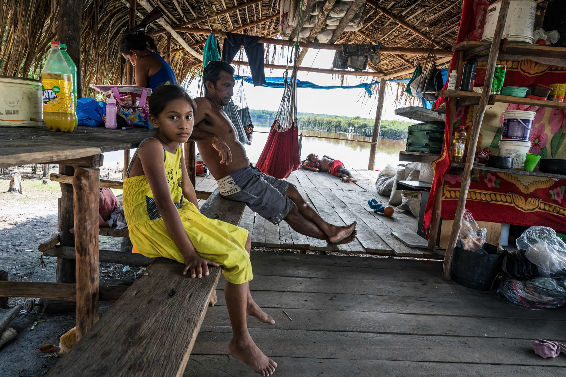 A local family in their temporary shelter where they will stay several months during the dry season while fishing in the Urubu river. Amazonian rainforest, Amazonas state, Brazil, November 2020