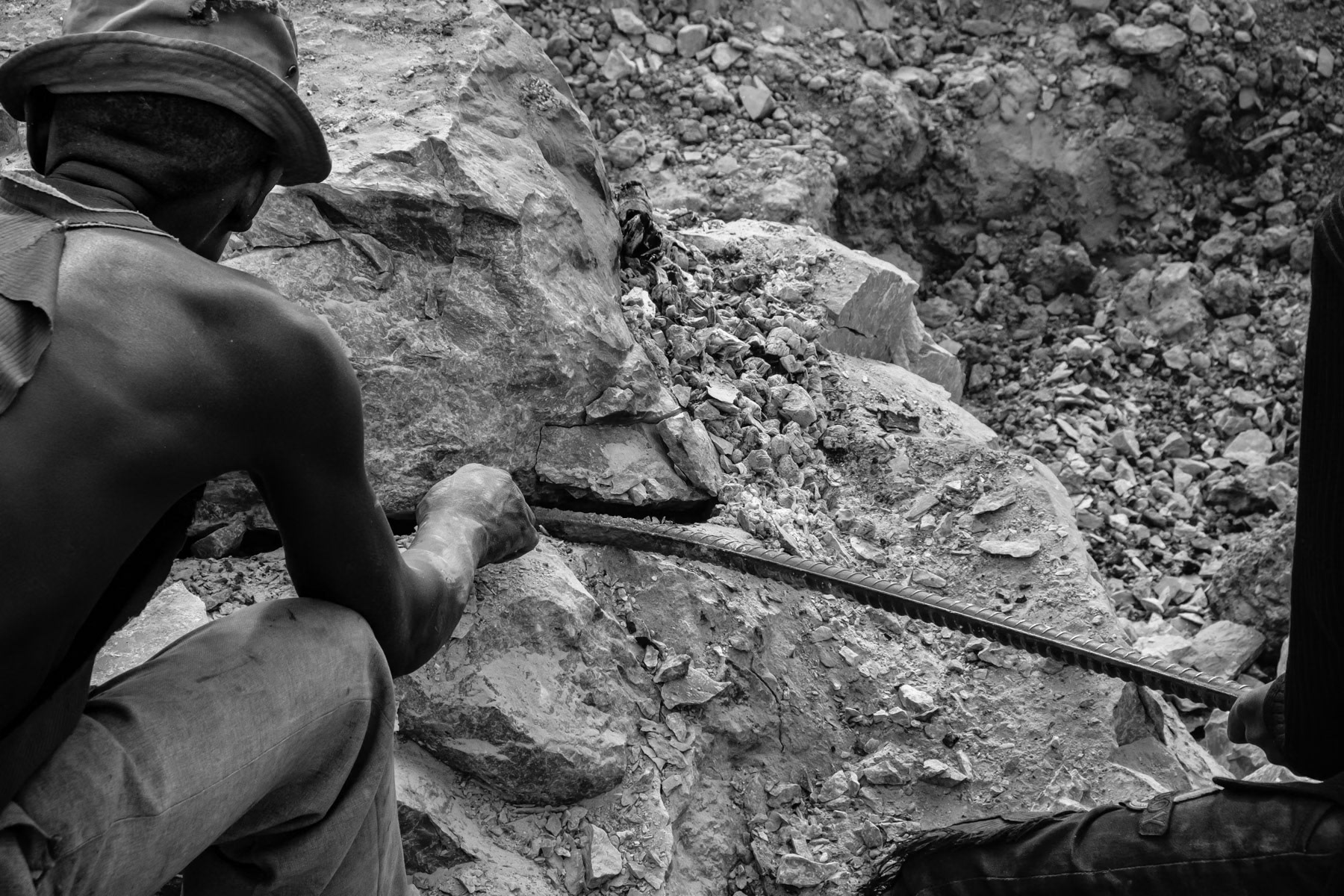 Makululu open pit mine where galena, the mineral form of lead, and dolomite a source of magnesium oxide are being mined by the local community. All labour, including stone crushing is done by hand. Rocks are being burned to make them softer before being extracted. Kabwe, Zambia, May 2021