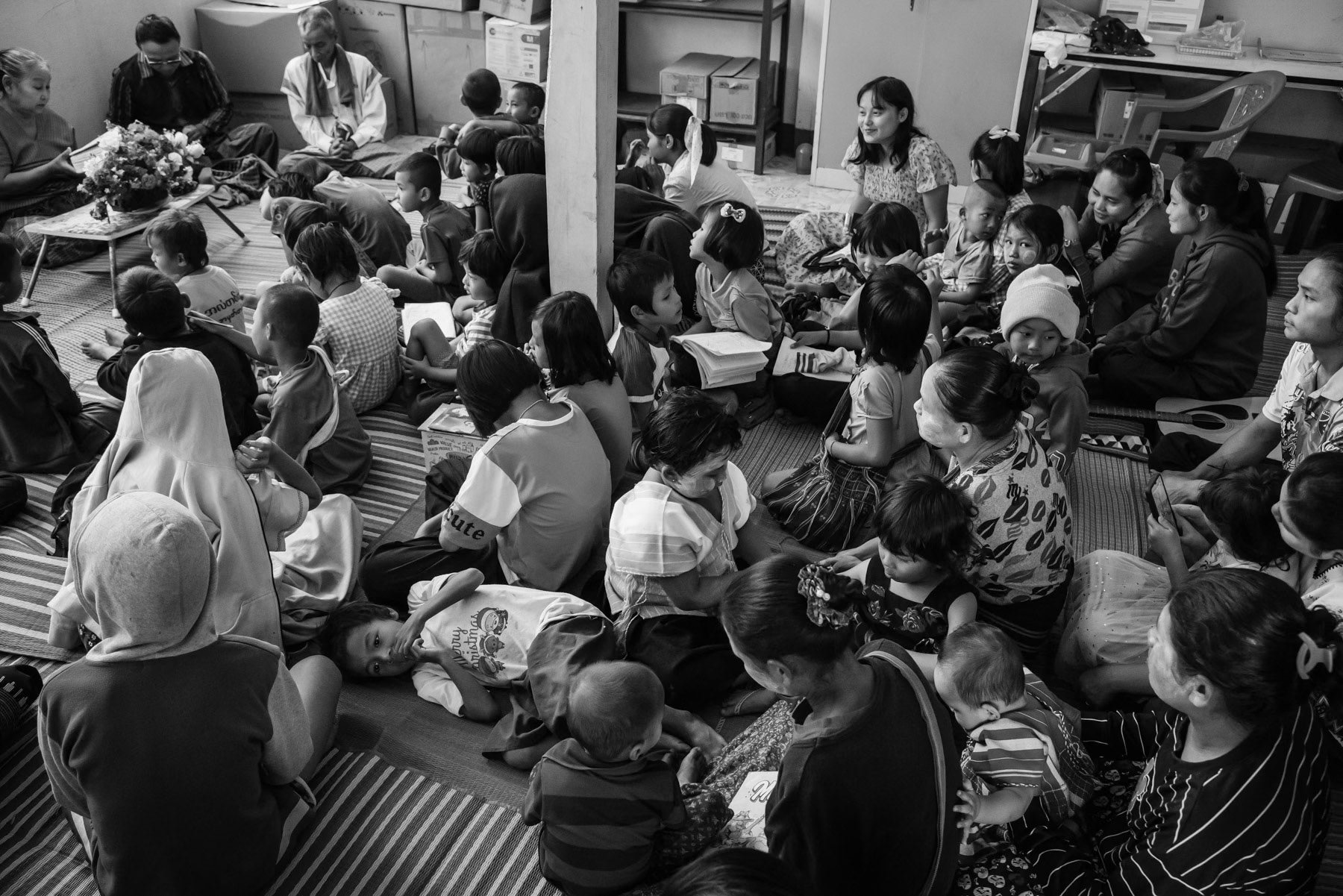 Karen children and parents attending church in the local clinic building. An important part of the Karen ethnic minority is Christian. Lae Gho clinic, Kayin, Myanmar, January 2024