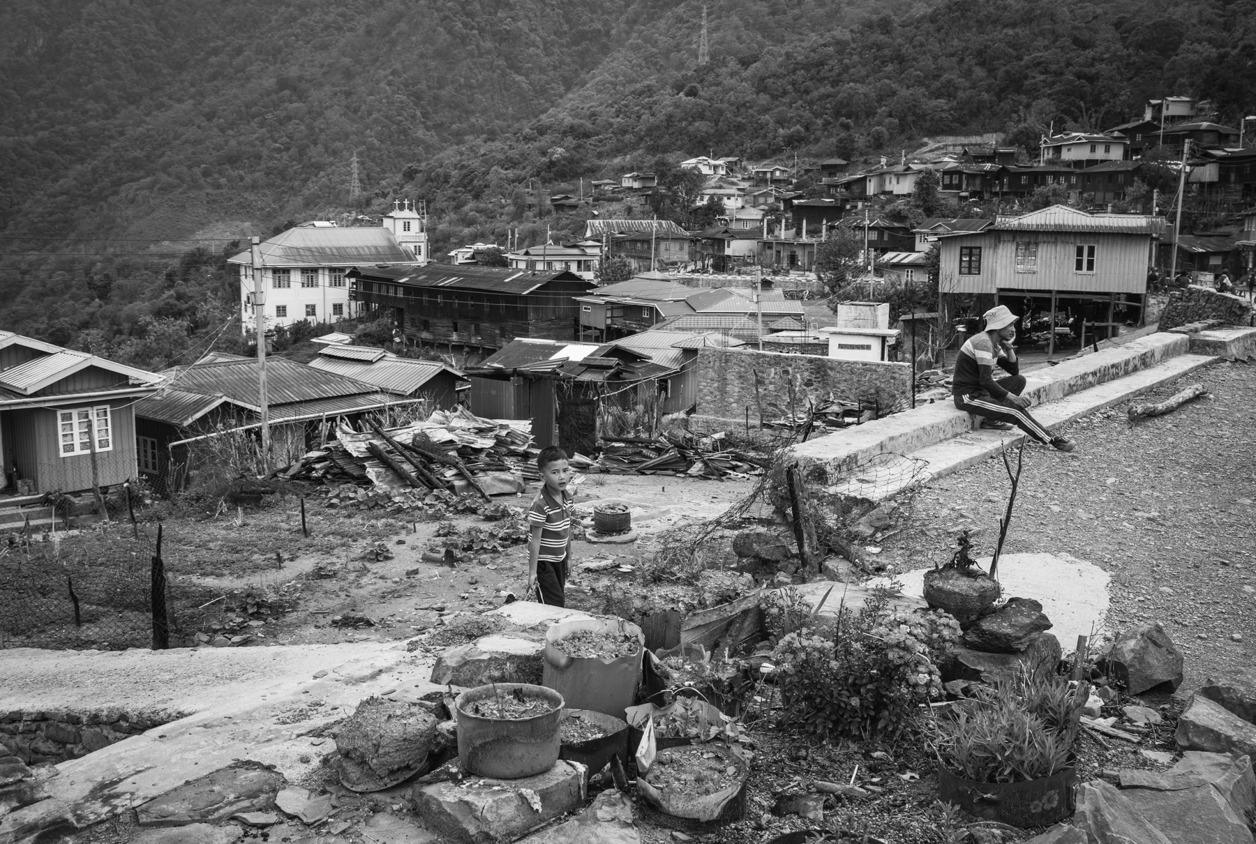 Chin villagers from Ramlau, a mountain village on the main road between Falam to Hakha. The village was ransacked by the Myanmar military (Tatmadaw) during the passage of their militarty convoy going through Chin State. The military convoy was attacked continously by Chin Defense Forces (CDF) and Chin National Defence Forces (CNDF), the Myanmar military took revenge actions by burning and exploding 19 houses in Ramlau and ordering airstrikes. The population had already evacuated the village a couple of days before the passage of the convoy. Ramlau has 850 habitants, 3 weeks after the raids and airstrikes barely 50% of the population has returned from hiding in the hills and surrounding farms. The airstrikes which are still a high risk targetted the school building sheltering IDPs. Tatmadaw stayed 4 days in the village until 7 May 2023, during which they looted and burned houses. Ramlau village, Falam township, Myanmar, May 2023