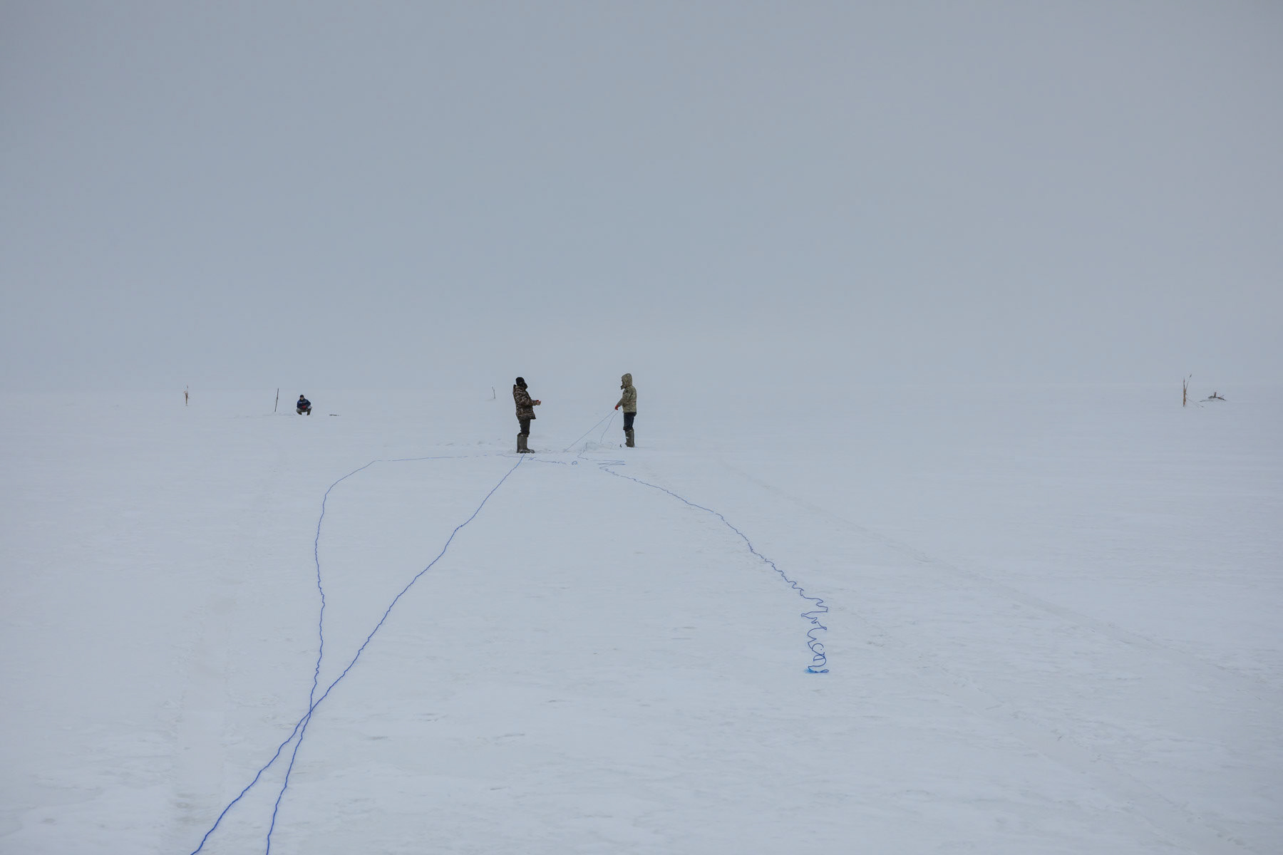 Fishermen on the frozen Aral Sea. The temperatures reach minus 20-30C during winter months and the ice fishing season lasts about 3-4 months. Aral Sea, Kazakhstan, January 2019
