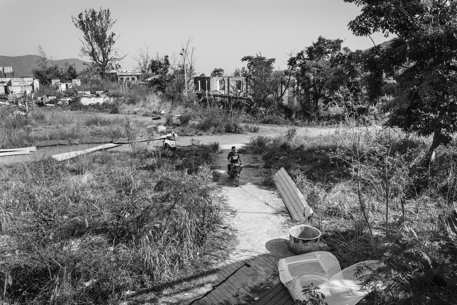 Thantlang, a town of 12,000 before the war is now completely evacuated of its civilian population. The town has been completely destroyed and mostly burned to the ground. Until this day the town is divided between a Myanmar military conrolled part and the other half controlled by the Chin Defense Forces (CDF). Merely a couple of hundred meters separates them downtown. Some of the most violent and intensive combats in Chin State are taking place to this date in Thantlang. CDF positions in a hospital buiding on the frontline. Thantlang downtown, Chin State, Myanmar, April 2024