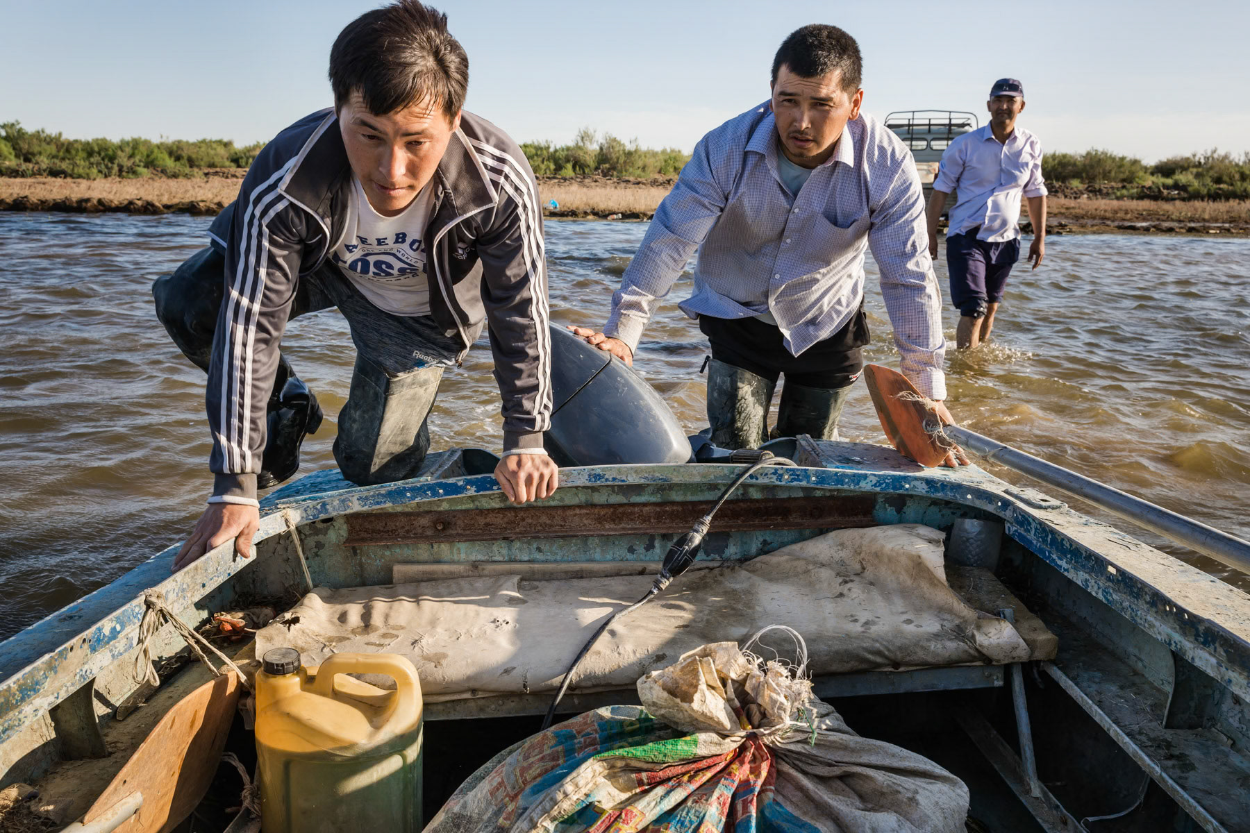 Start of the fishing season, fishermen going to throw fishing nets in the late afternoon. Akbasty, Aral Sea, Kazakhstan, June 2019