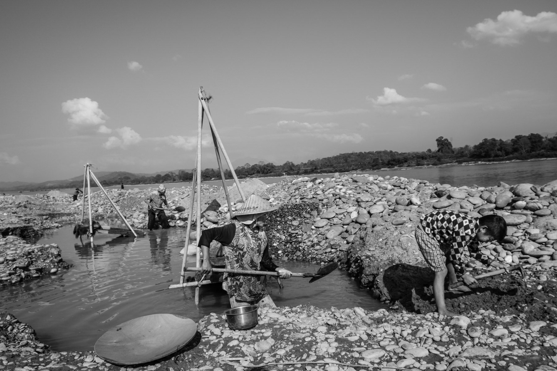 Kachin women from the Lazi ethnic sub-group digging along the shores of the Irrawaddy River to find gold and making in average 5-7 USD a day. They are allowed to do this activity for only a couple of months during the winter season. Lazi villages north of Myitkyina, Kachin State, Myanmar, February 2020
