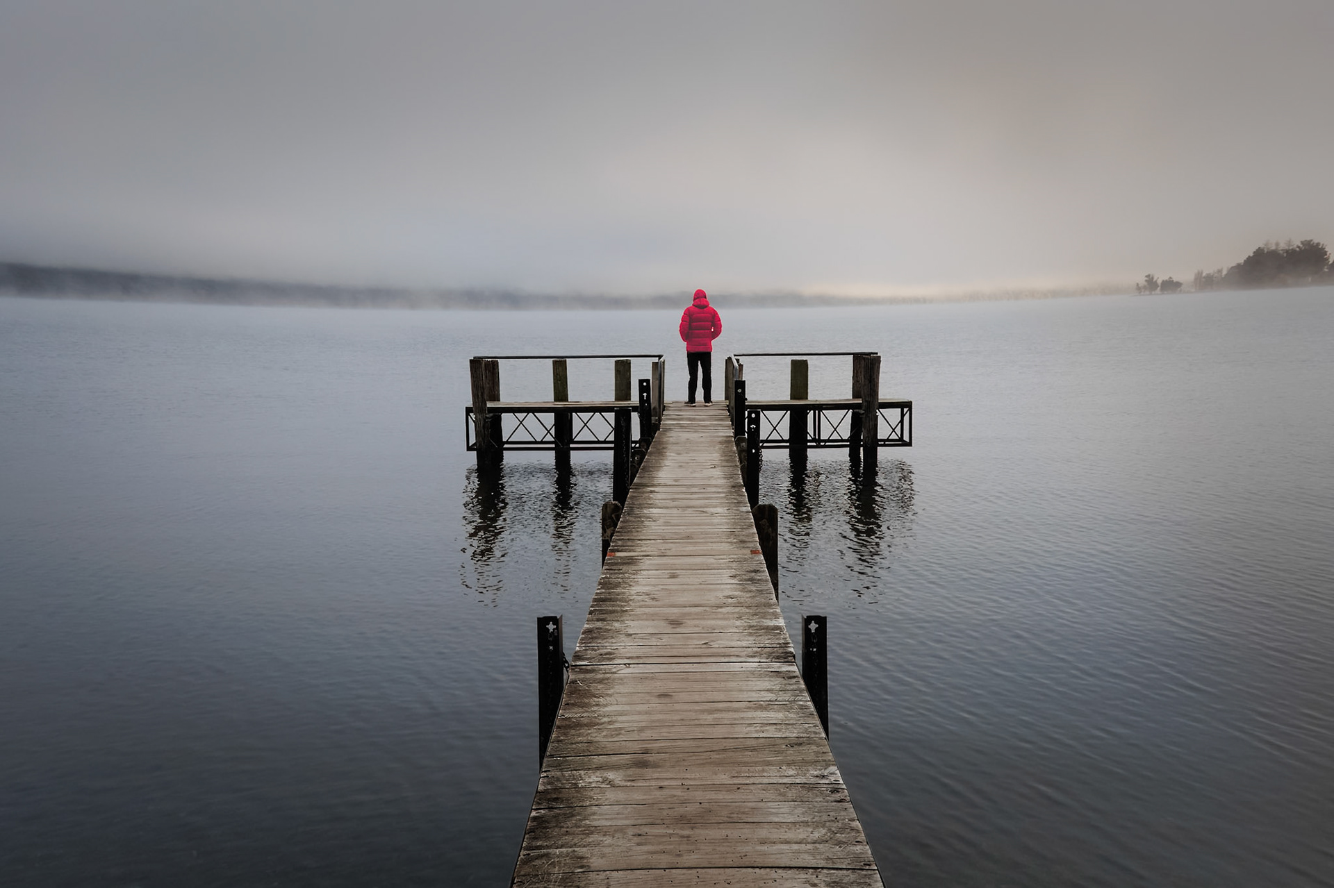 Man with a red jacket on a jetty