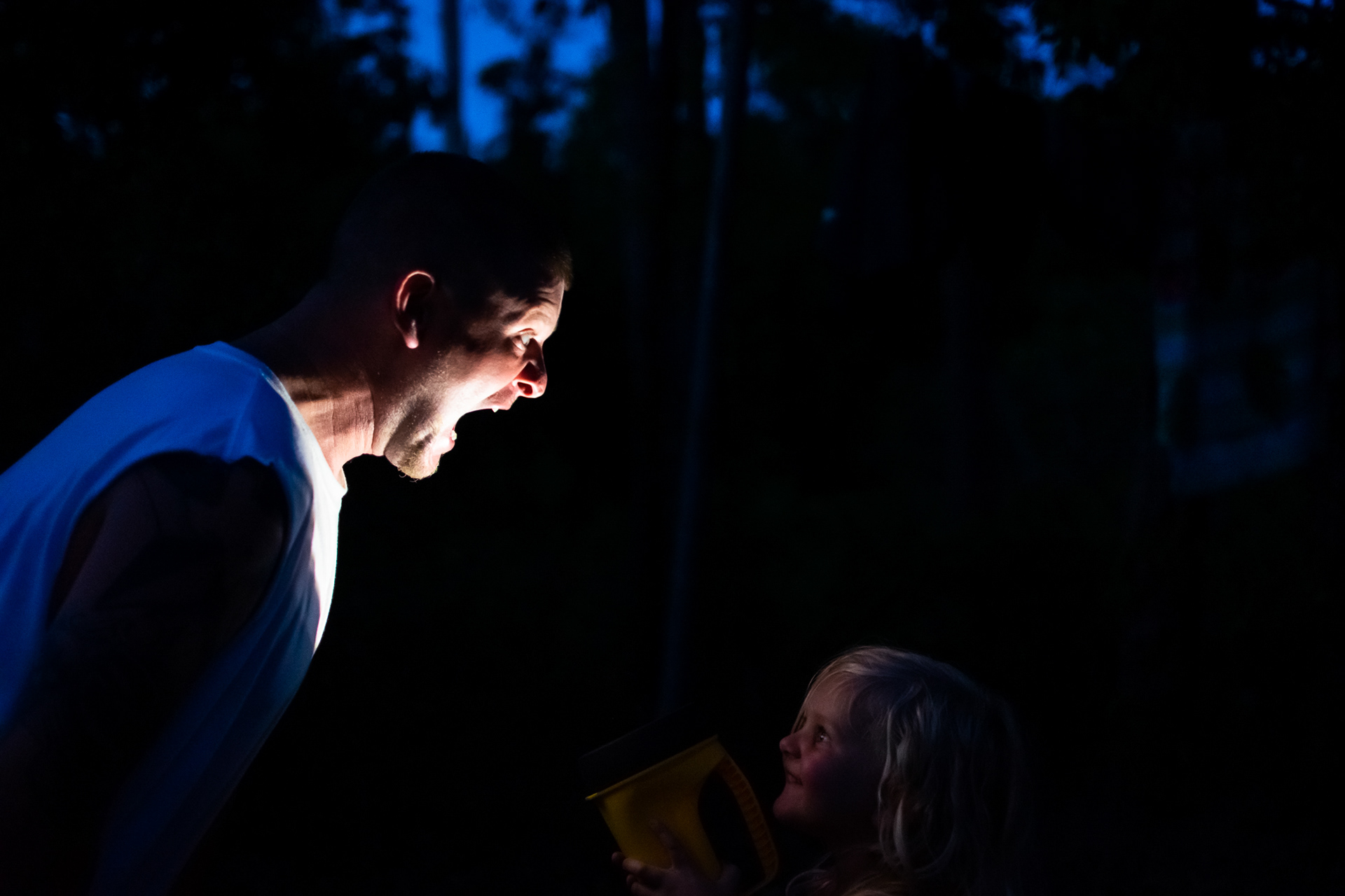 My husband attempting to scare my daughter with ghost stories while camping.