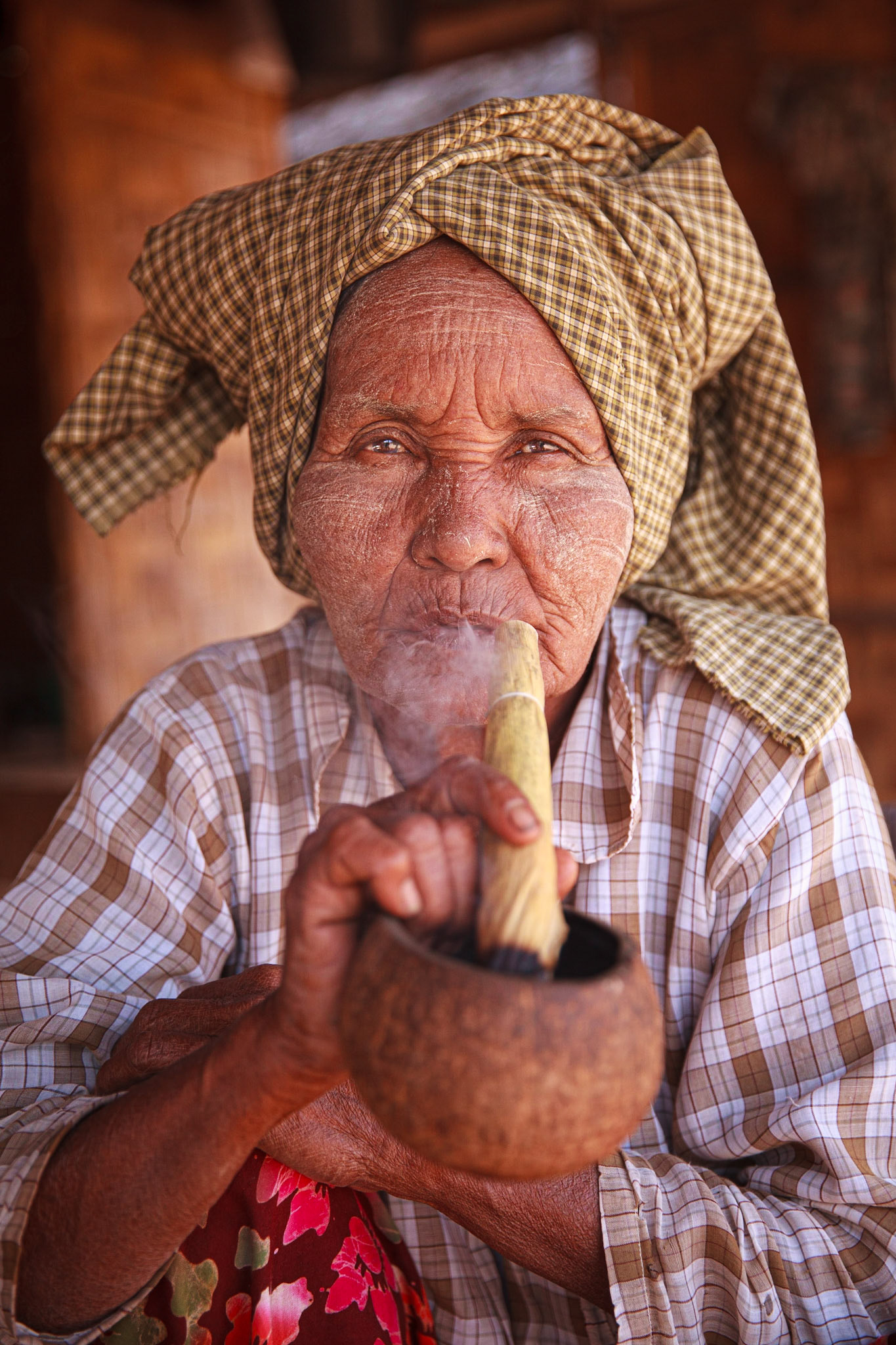 Cheroot smoking is popular in many parts of Myanmar, especially amongst older women. Many villages supplement their income making these types of cigar from tobacco, corn husk and spices. After satiating myself with the multiple temples of Bagan,I wandered into a nearby village for respite and found this lady also having a break from her daily tasks.  Many of the women and children of Myanmar still smear thanaka, a traditional sunscreen/cosmetic paste made from ground bark, on their faces. She was happy to have her photo taken as long as I tried a puff as well.