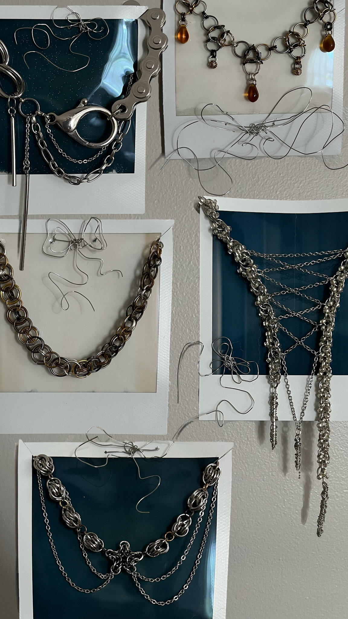 Collection of self-designed chainmail necklaces mounted on expired polaroid film