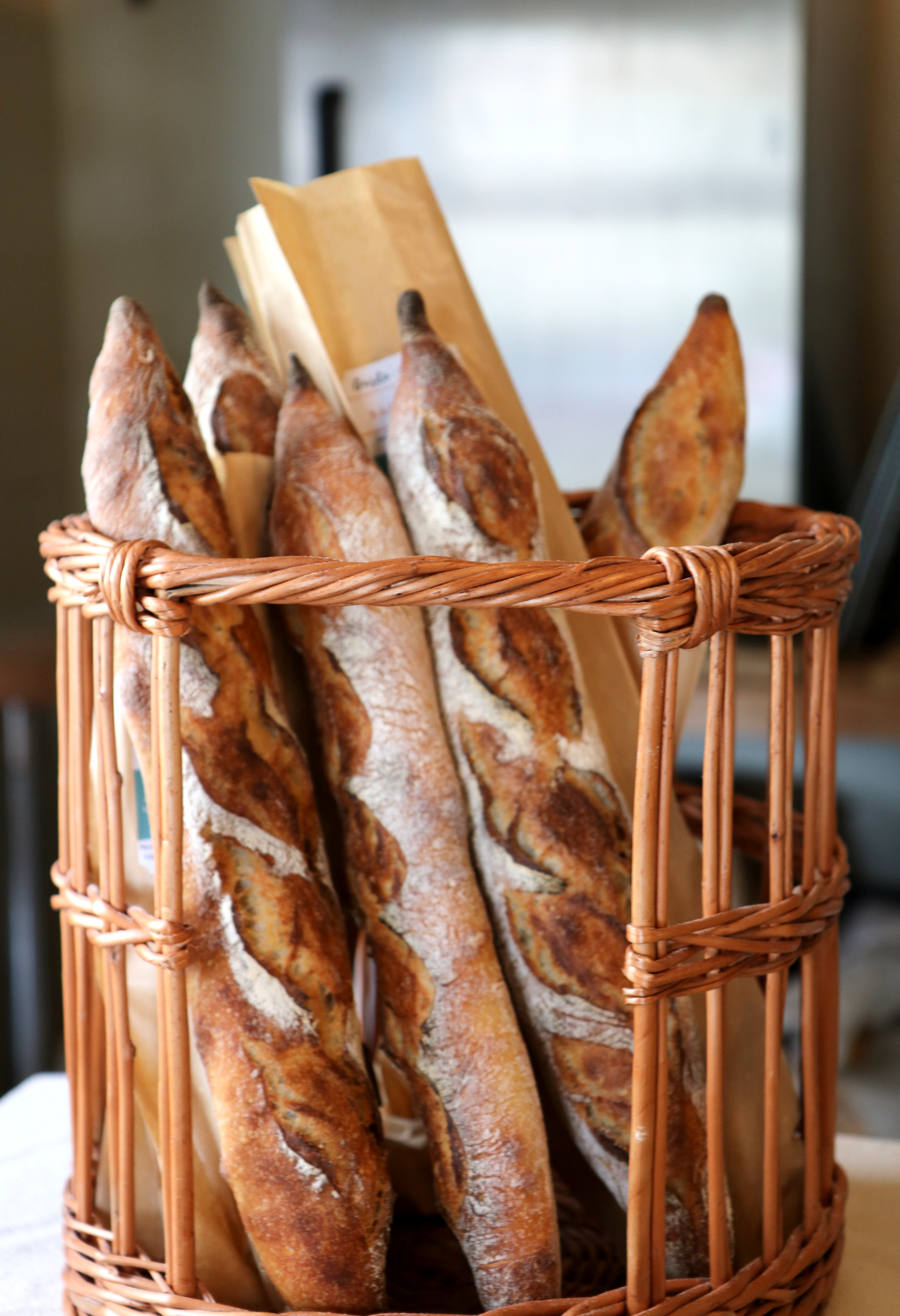 A basket of fresh baguettes made by Gusto Bread.