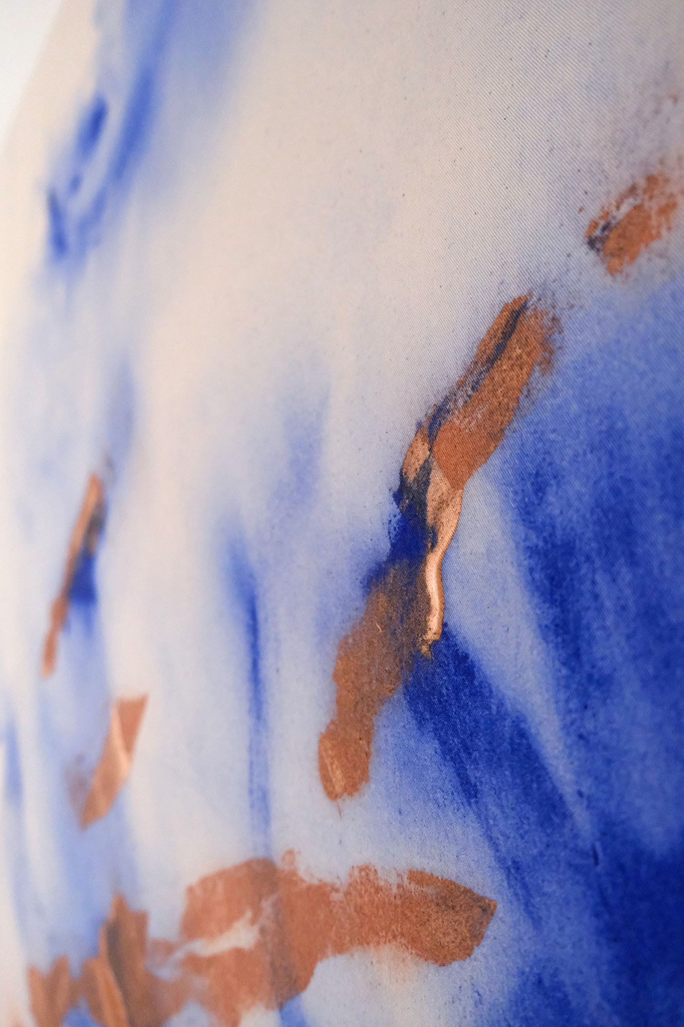 Abstract painting titled "Copper Echoes" by Anne Marie Kersten, featuring fluid blue washes and striking copper accents on a natural beige canvas background. Abstraktes Gemälde mit dem Titel "Copper Echoes" von Anne Marie Kersten, mit fließenden blauen Farbverläufen und auffälligen kupferfarbenen Akzenten auf naturfarbenem Leinwandhintergrund.