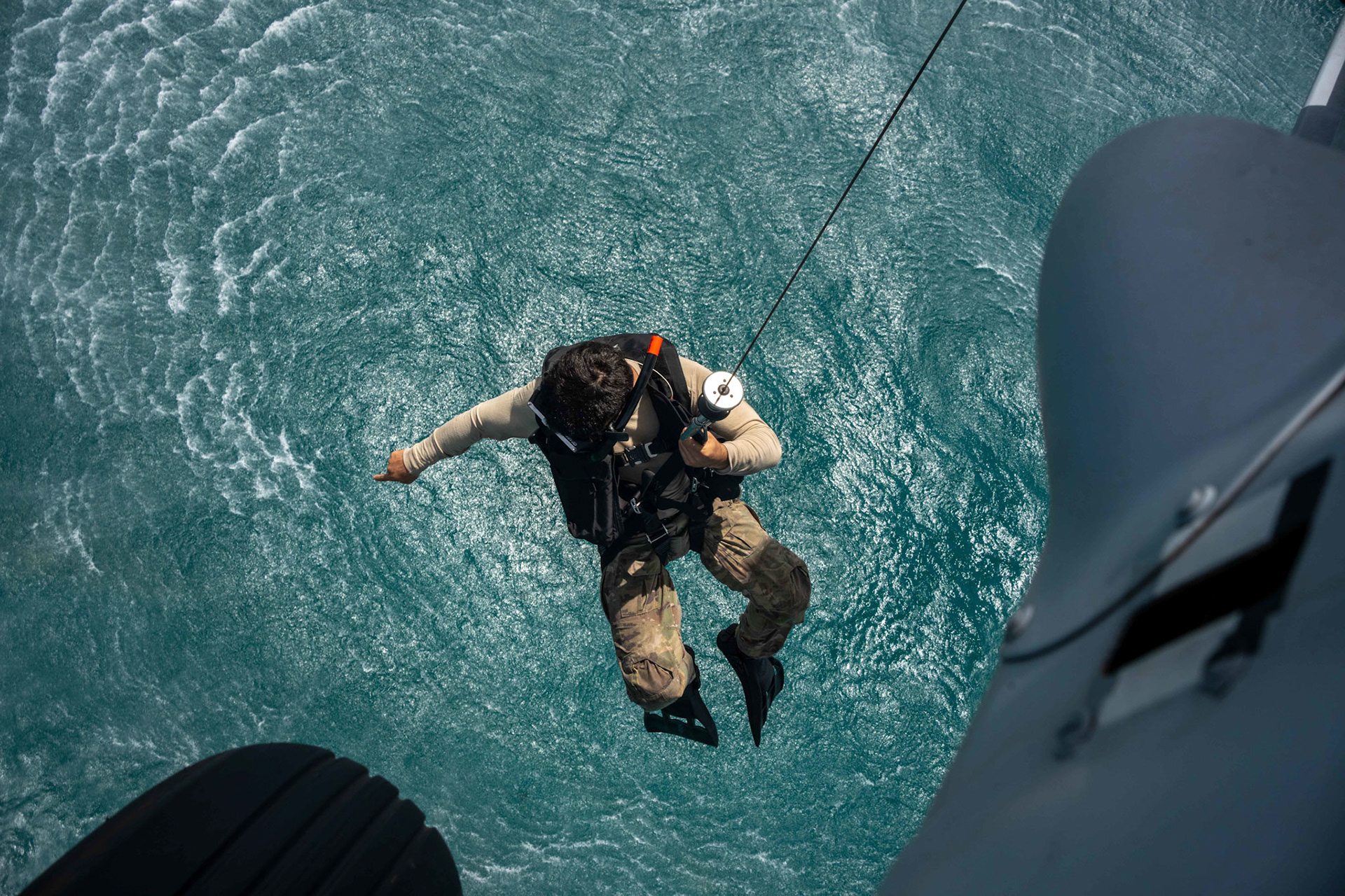 220511-A-YK067-1141 ARABIAN GULF (May 11, 2022) Naval Aircrewman (Helicopter) 2nd Class Hunter Hill, assigned to Helicopter Sea Combat Squadron (HSC) 26, lowers from an MH-60 Knighthawk during an at-sea search and rescue training operation during Exercise Neon Defender 2022. Neon Defender is an annual bilateral training event between U.S. Naval Forces Central Command and Bahrain. The exercise focuses on maritime security operations, installation defense and medical response. (U.S. Army photo by Sgt. Terry Vongsouthi)