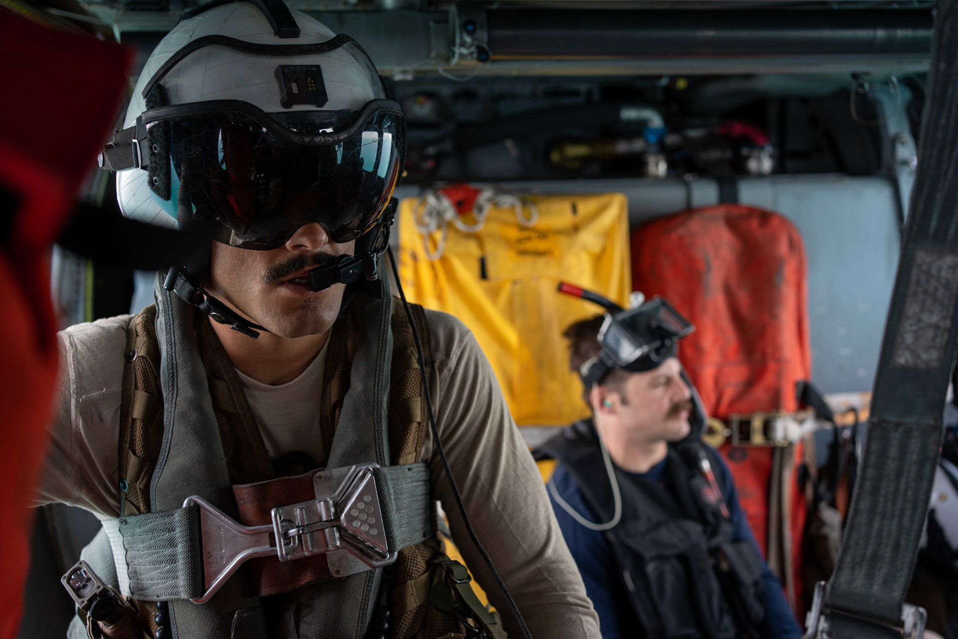 220511-A-YK067-1022 ARABIAN GULF (May 11, 2022) Naval Aircrewman (Helicopter) 2nd Class Hunter Hill, left, and Naval Aircrewman (Helicopter) 2nd Class Seth Brumaghin, assigned to Helicopter Sea Combat Squadron (HSC) 26, fly in an MH-60 Knighthawk during an at-sea search and rescue training operation during Exercise Neon Defender 2022. Neon Defender is an annual bilateral training event between U.S. Naval Forces Central Command and Bahrain. The exercise focuses on maritime security operations, installation defense and medical response. (U.S. Army photo by Sgt. Terry Vongsouthi)