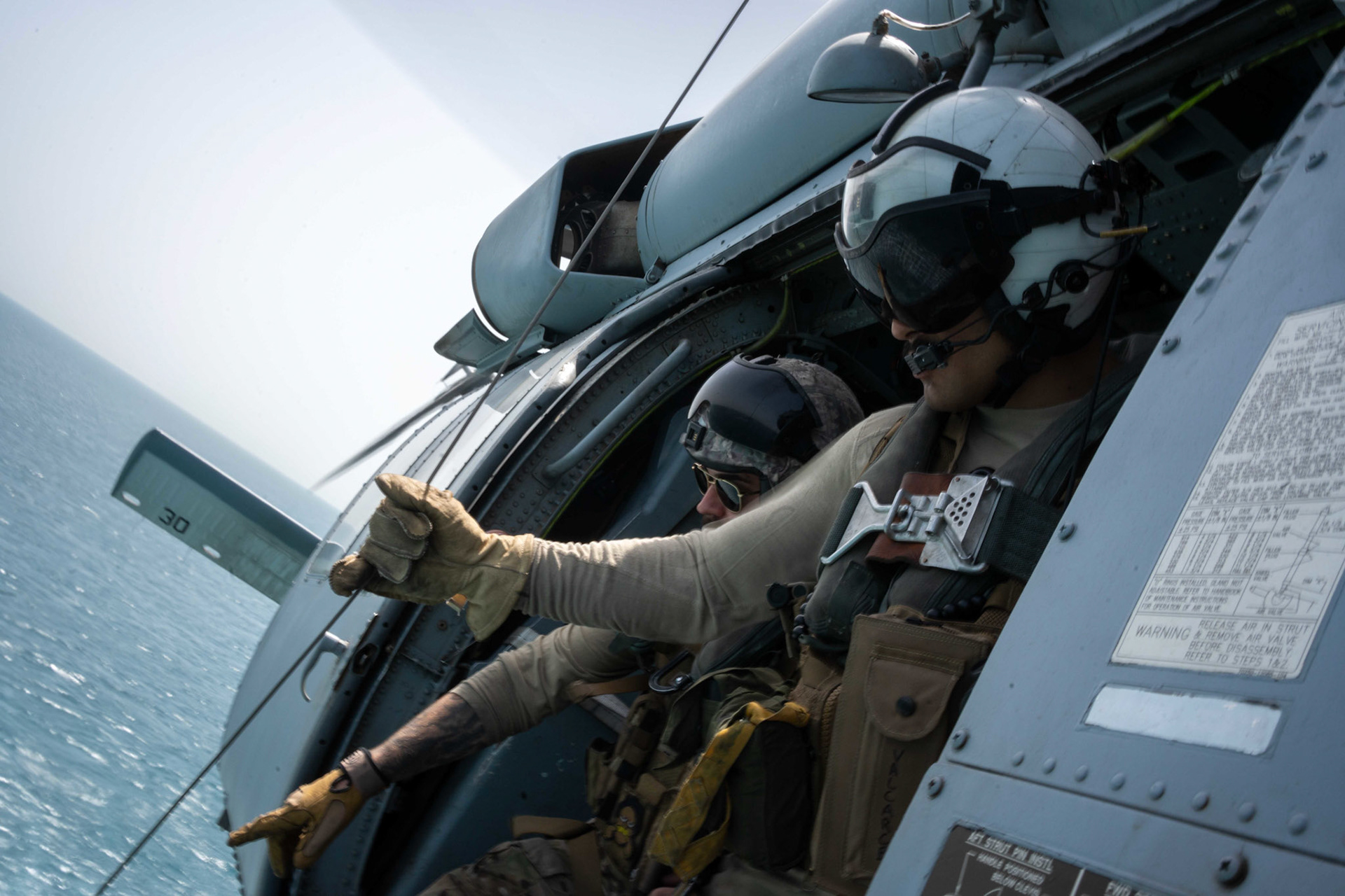 220511-A-YK067-1121 ARABIAN GULF (May 11, 2022) Naval Aircrewman (Helicopter) 2nd Class Hunter Hill, right, and Lt. Evan Sternstein, assigned to Helicopter Sea Combat Squadron (HSC) 26, participate in an at-sea search and rescue training operation during Exercise Neon Defender 2022. Neon Defender is an annual bilateral training event between U.S. Naval Forces Central Command and Bahrain. The exercise focuses on maritime security operations, installation defense and medical response. (U.S. Army photo by Sgt. Terry Vongsouthi)