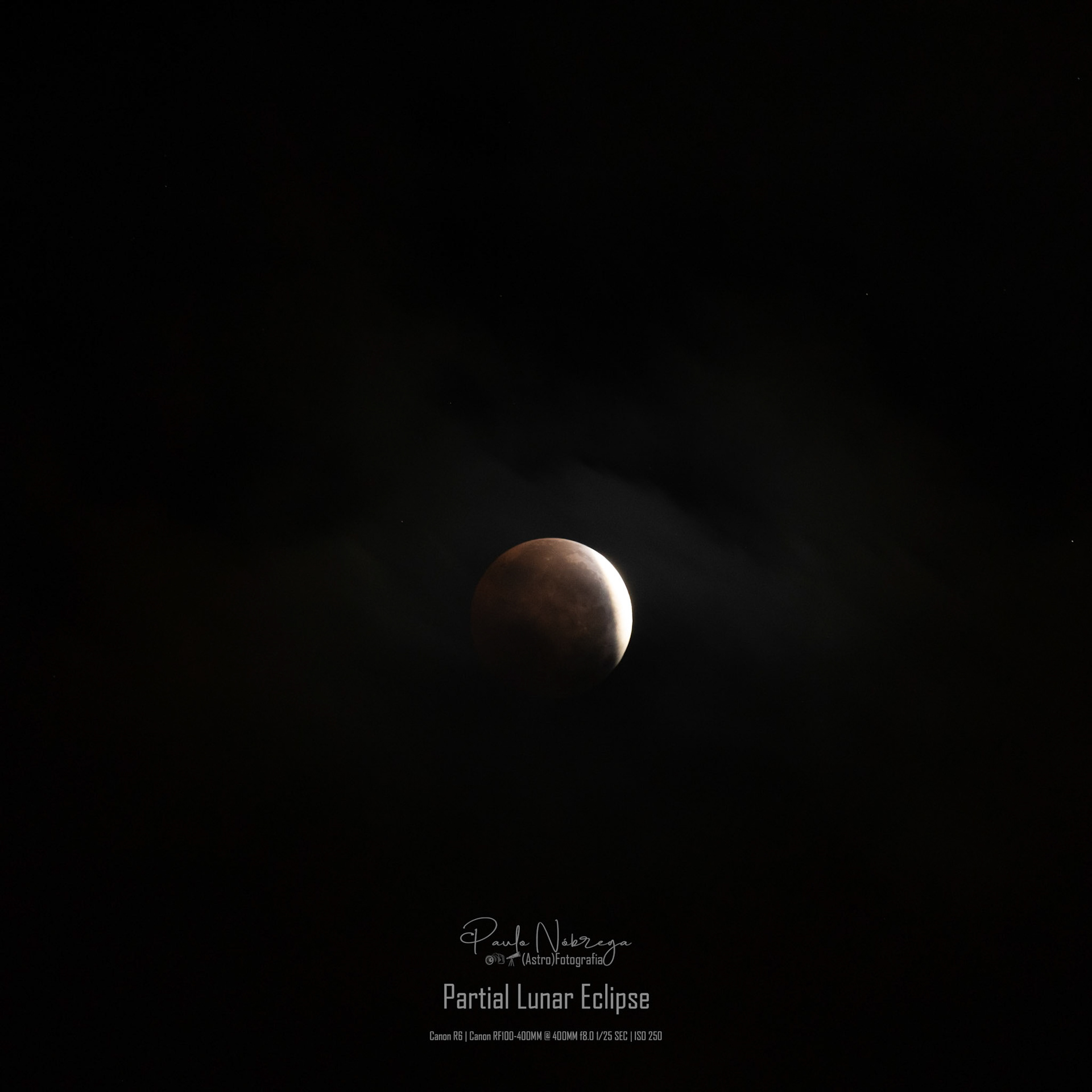 A sliver of sunlight during the Partial Lunar Eclipse. Captured against deep space with subtle wisps of passing clouds, revealing both the intense illuminated crescent and the soft gradient of Earth's shadow across the lunar terrain.