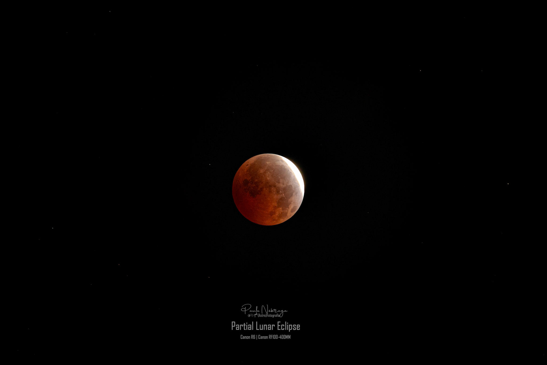 Peak of the Partial Lunar Eclipse. The lunar surface is bathed in Earth's shadow (umbra), revealing the characteristic coppery red hue caused by all of Earth's sunrises and sunsets refracting through our atmosphere.