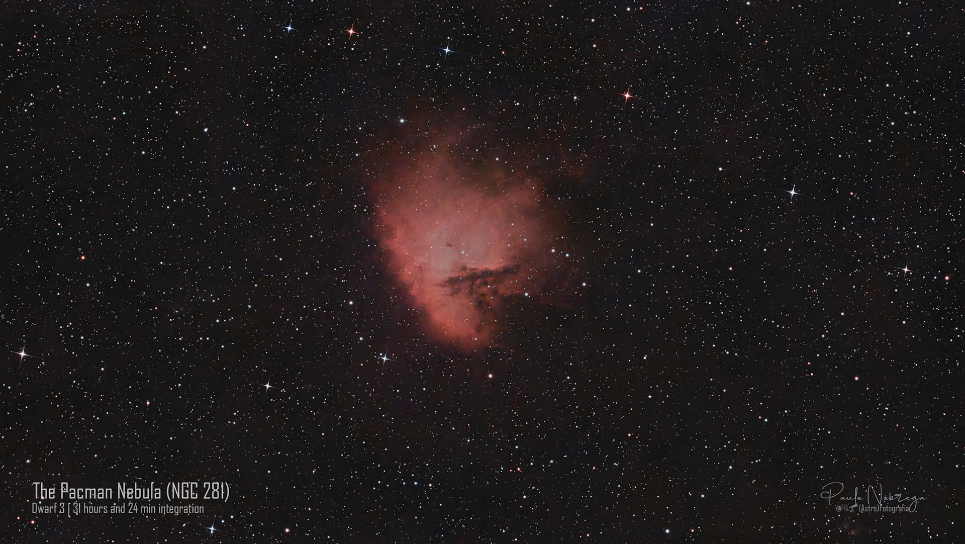 The Pacman Nebula (NGC 281 / IC 11) — H II Region in CassiopeiaSituated approximately 9,500 light-years away in the constellation Cassiopeia, NGC 281 earned its popular nickname due to its resemblance to the classic arcade character Pac-Man. This wide-field deep-sky capture highlights the vibrant ionized emission gas punctuated by dense lanes of obscuring cosmic dust and prominent Bok globules—compact, cold clouds of interstellar gas where new stellar systems are currently collapsing and taking shape.