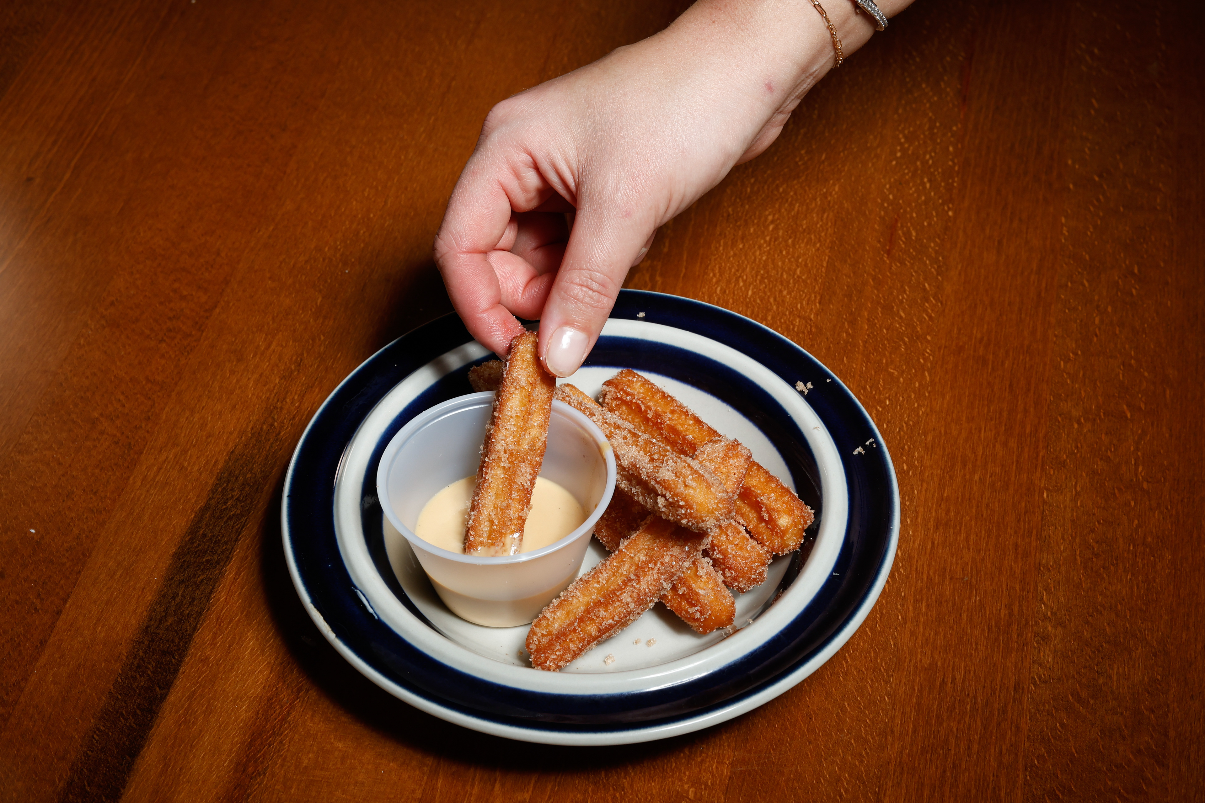 Churro sticks are dipped into salted caramel crème anglaise on Wednesday, Dec. 31, 2025 at Zeebo's in Long Beach, NY