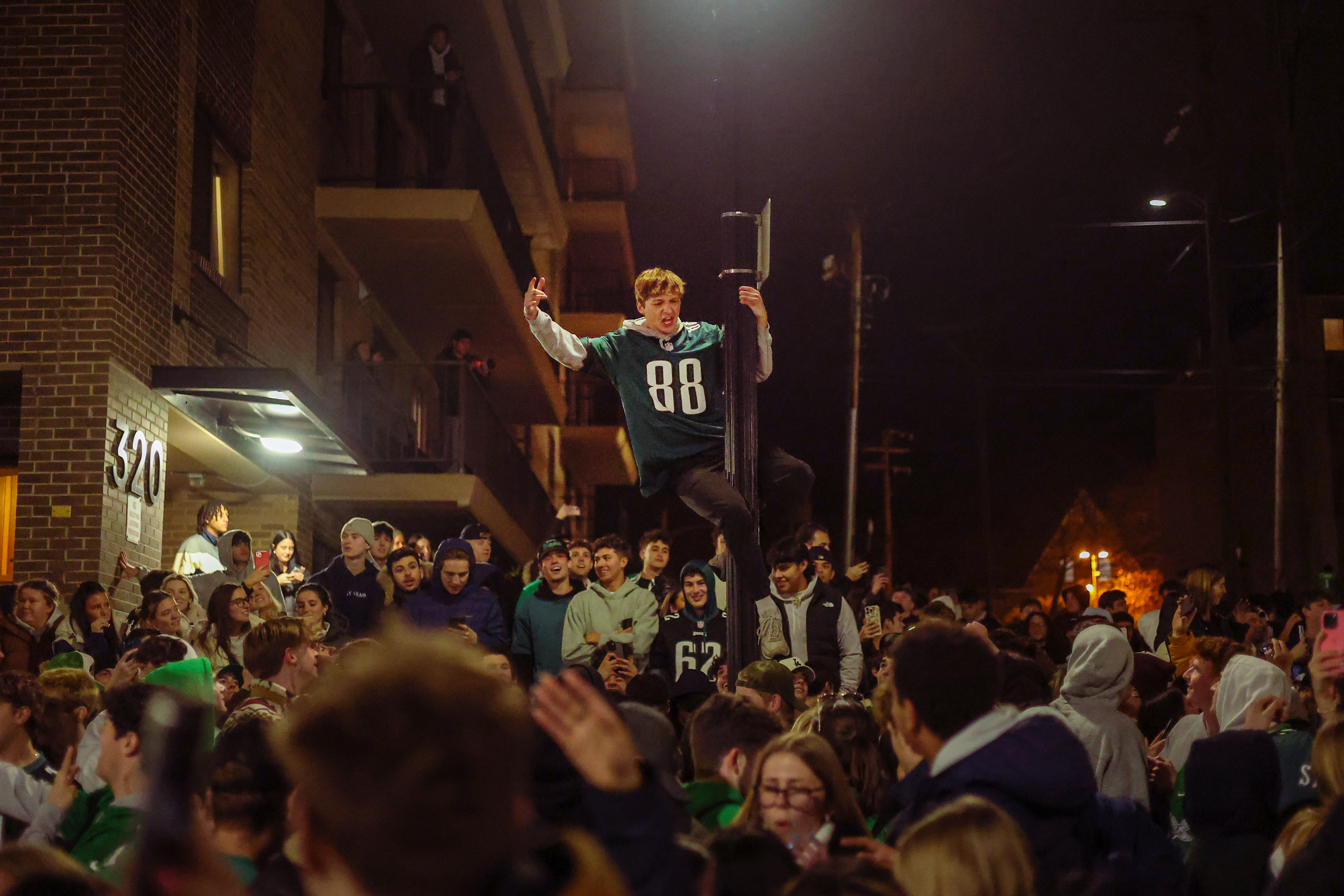 A Philadelphia Eagles fan climbs a lamp post on Sunday, Feb. 9, 2025 in State College, Pa. The Eagles beat the Kansas City Chiefs 40-22 in Super Bowl LIX.