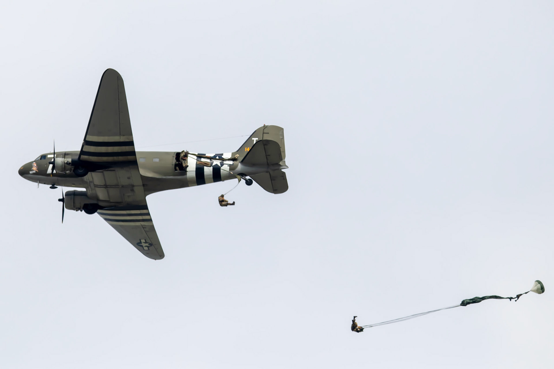 A C47 flys over dropping paratroopers
