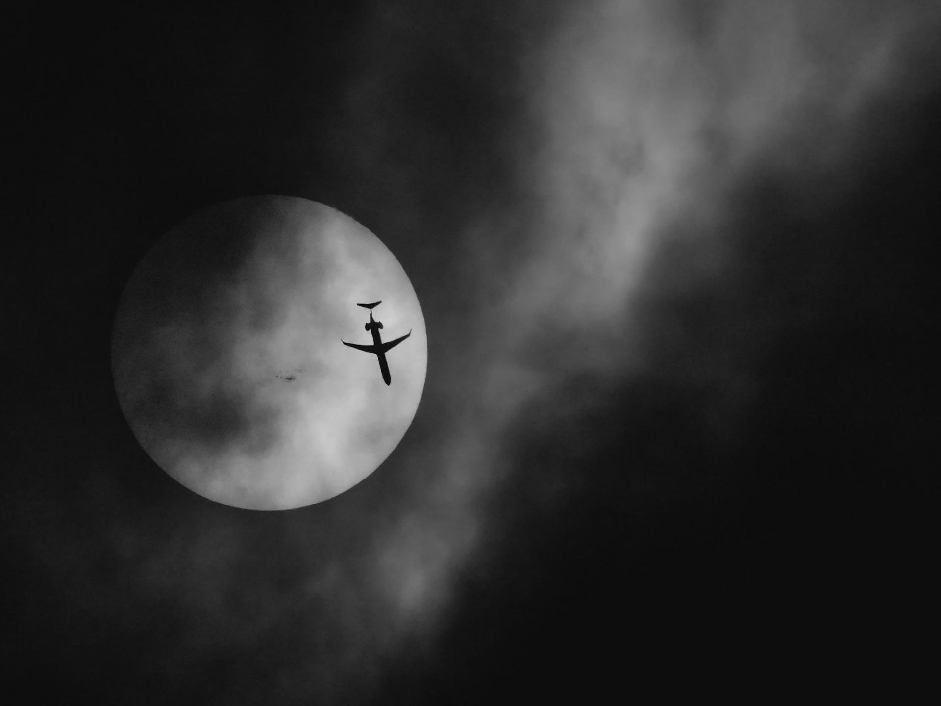 A Mitsubishi Heavy Industries CRJ-900LR (reg N554NN) passing in front of the Sun, seen through thick clouds Saturday. American Airlines flight 5110 was flying from Charlotte (CLT) to Freeport (FPO) at 25,000 feet and 442 knots as it passed over the Space Coast. The clouds were *really* thick and I was hoping for a break that would allow a clear view of the Sun. When I think a transit might be possible, I'll usually adjust the exposure settings constantly to keep the Sun visible, mainly for planning purposes. For this, I had bumped the ISO to 25,600 in order to keep the shutter speed high (1/1000). At first, I thought the image to be unusable, but in black and white it sort of captures the mood of a cloudy day. (📷:me, flight data by Flightradar24.com)