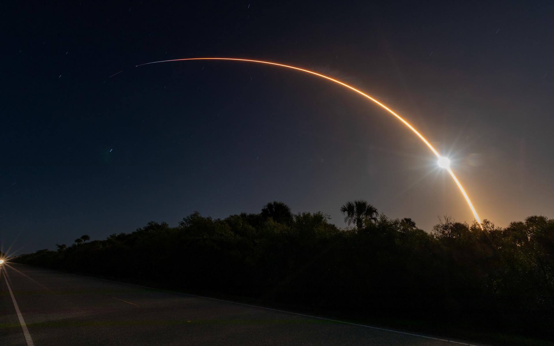Falcon 9 meets the Moon: the wide view.The only option I could find for a rocket/lunar alignment was along this narrow road, the A. Max Brewer Parkway, in Titusville. Although there's water (and things that live in the water) nearby, there was no clear view of the horizon for any reflection. But, the bright smudge is the 95% illuminated Moon, and you can see how far into the flight the transit occurred. I come at this with a clear (and obsessive) bias, for sure, but it's always funny to me that at 11:44 pm, there are people awake and not watching the rocket. I'm referring to the car (frame left) speeding toward me, causing me to end this exposure after 168-seconds to save the frame from the headlights. Details: 168-secs at ISO320 and f18 at 16mm with a Canon 5D4 / EF 16-35mm.