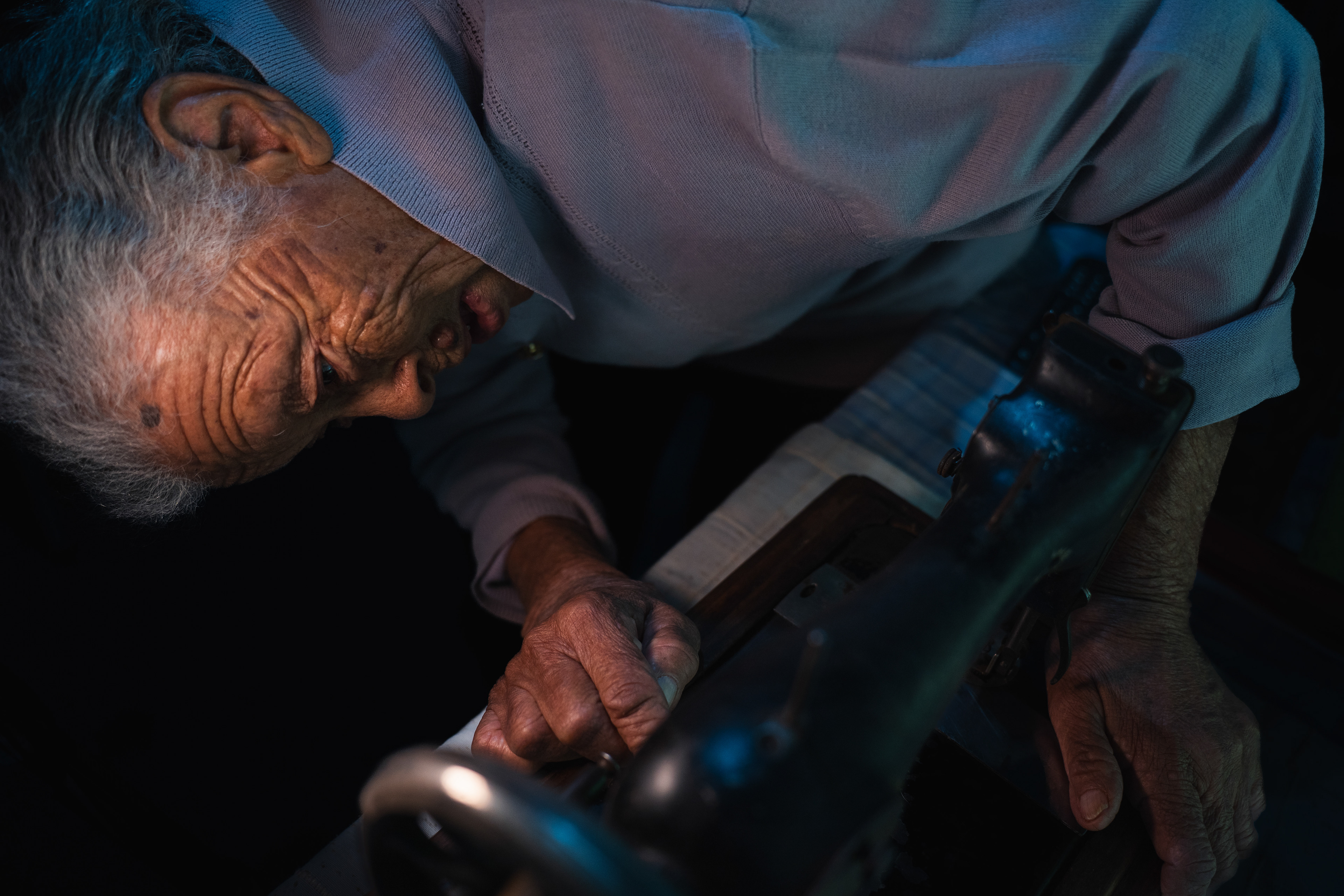 Aunty Edna examines an old sewing machine as she reminisces, "On our mother’s side, we had a Ndebele Gogo [Granny] and a British grandfather. Gogo learned to sew, so our grandfather bought her this sewing machine." 