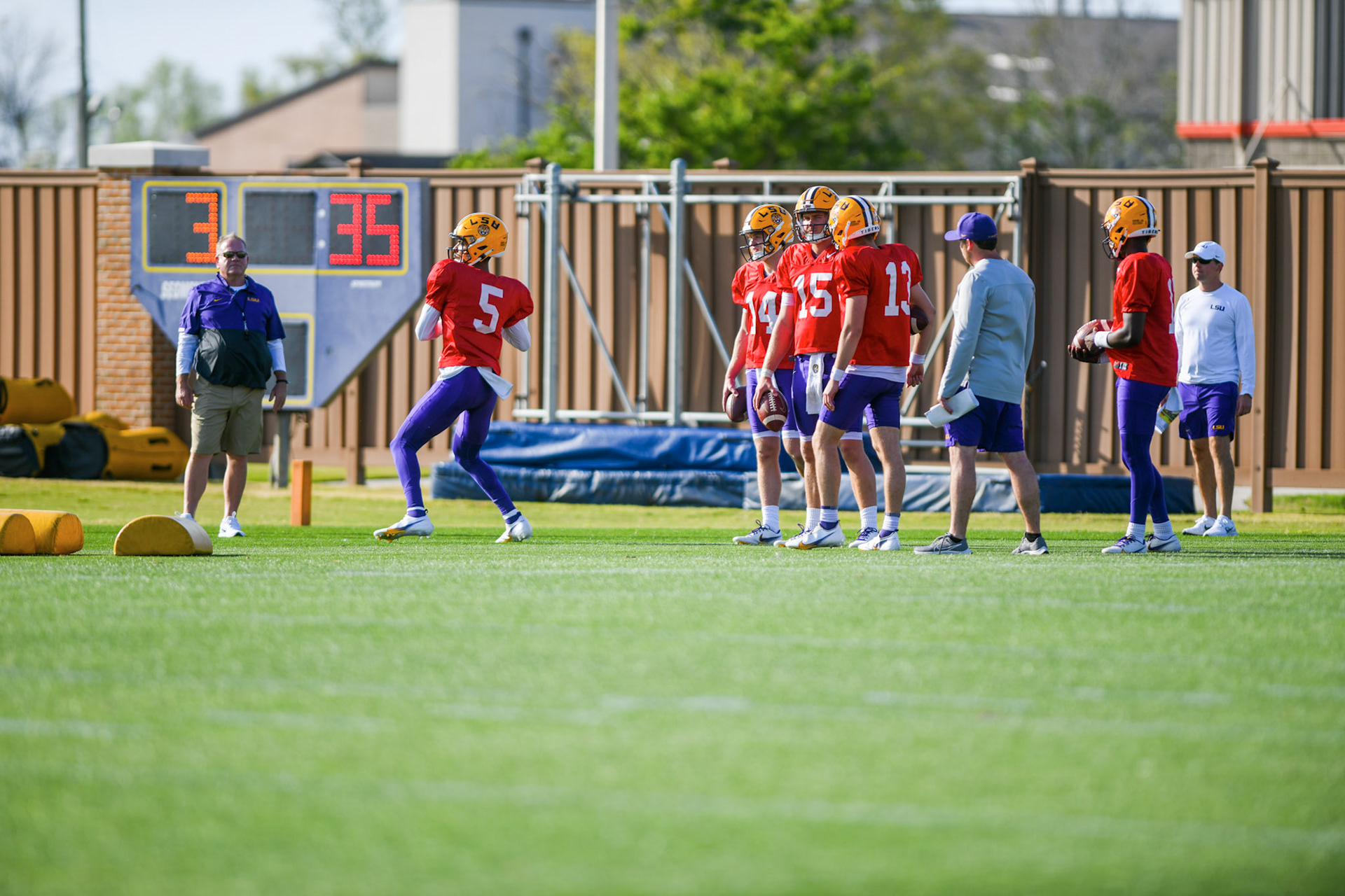 LSU football junior quarterback Jayden Daniels (5) throws the ball with head coach Brian Kelly viewing the drill Tuesday, March 29, 2022 during LSU's spring practice in Baton Rouge, La.
