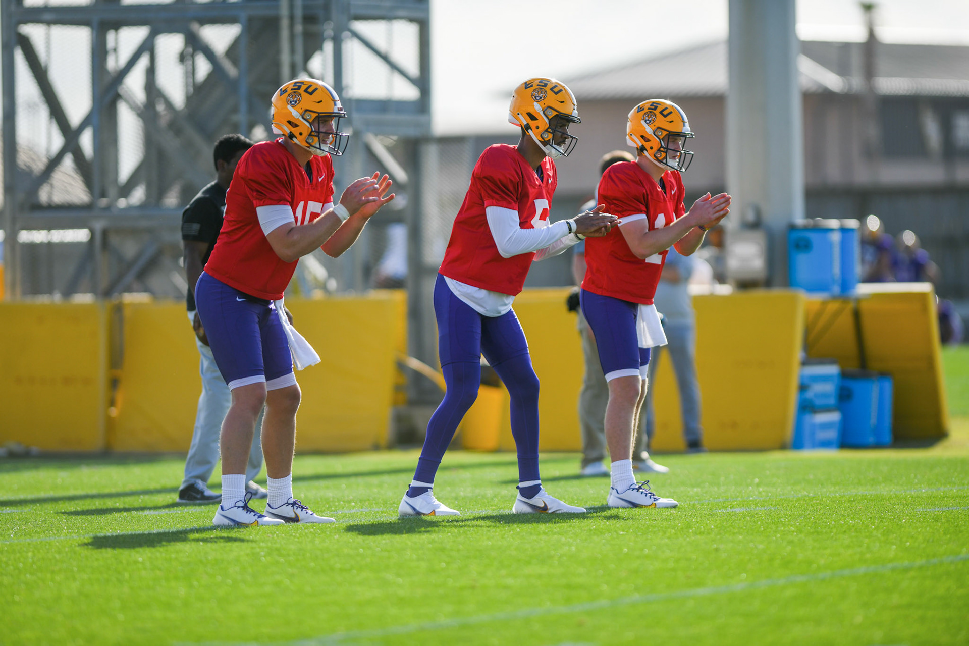 LSU football quarterbacks Myles Brennan (15), Jayden Daniels (5), and Walker Howard (14) wait to receive the ball Tuesday, March 29, 2022 during LSU's spring practice in Baton Rouge, La.
