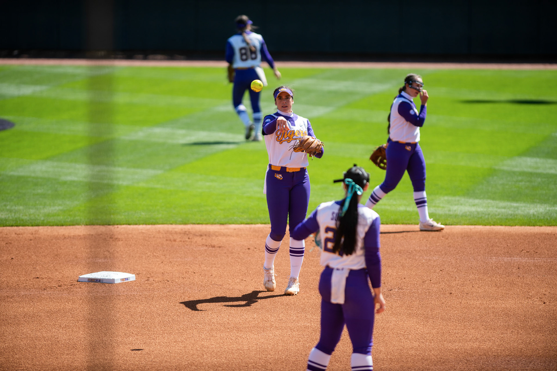 LSU softball redshirt sophomore infielder Taylor Pleasants (17) throws the ball to 5th-year senior pitcher/utility Shelbi Sunseri (27) Saturday, March 12, 2022 before LSU's 13-6 win against Alabama at Tiger Park in Baton Rouge, La.