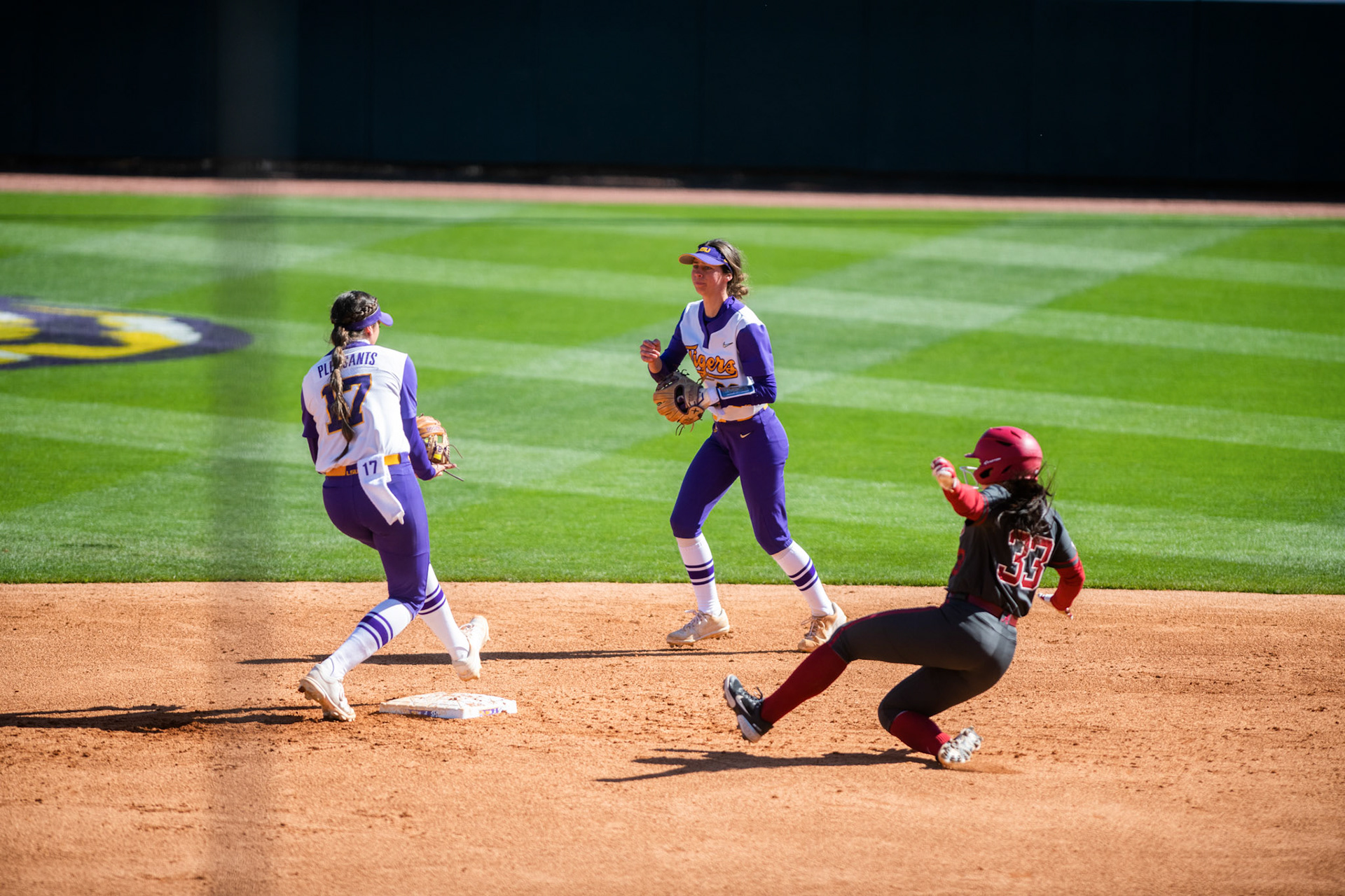 LSU softball redshirt freshman infielder Presley Pilon (99) tosses the ball to redshirt sophomore infielder Taylor Pleasants (17) to end the inning Saturday, March 12, 2022 during LSU's 13-6 win against Alabama at Tiger Park in Baton Rouge, La.