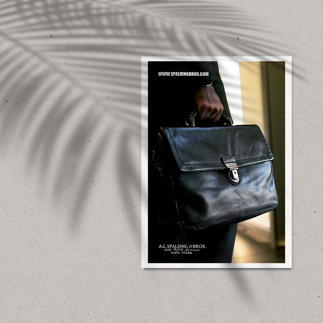 Cartolina pubblicitaria A.G. Spalding & Bros. con borsa professionale in pelle di alta qualità tenuta da dirigente in abito scuro davanti a un edificio direzionale.