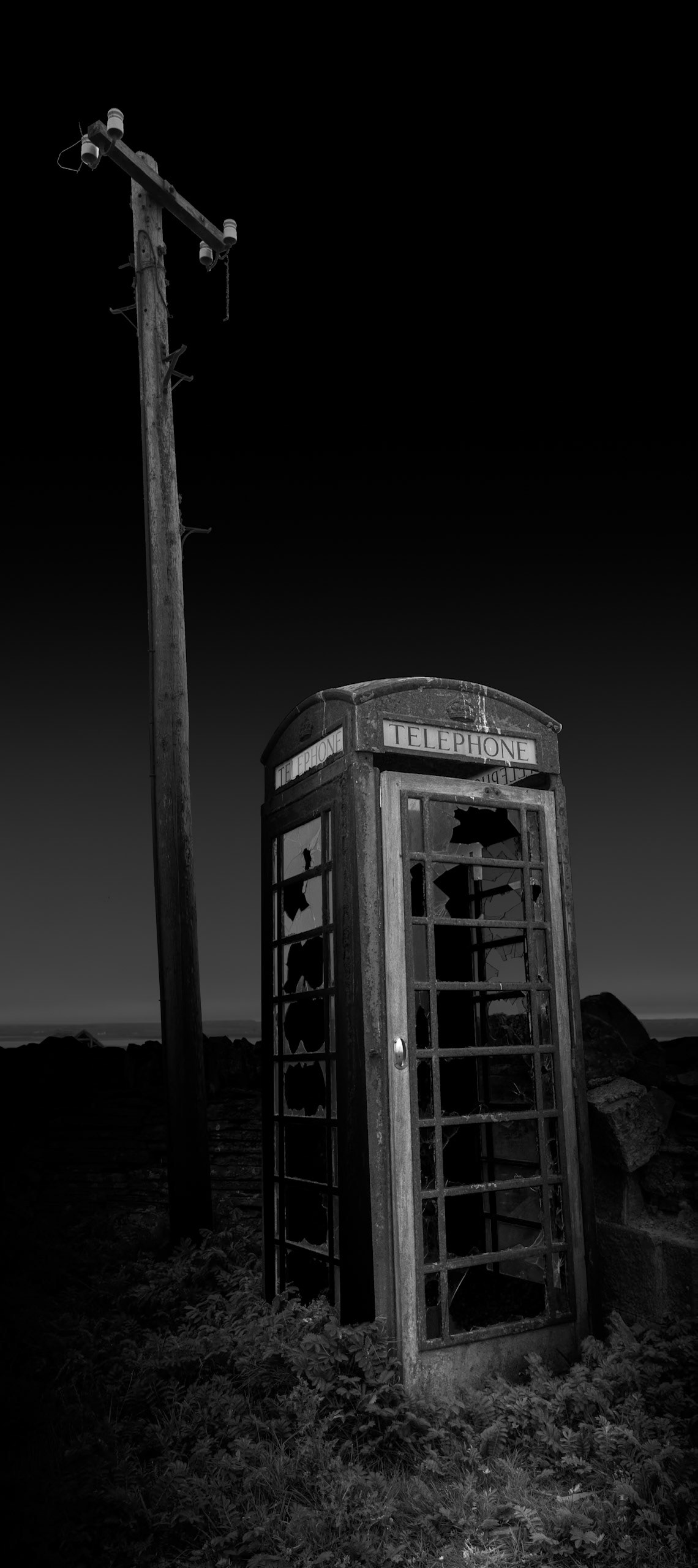Standing alone beneath its telegraph pole, Stroma's telephone box is an unexpectedly familiar object in an extraordinary setting. It once formed part of the infrastructure connecting the island's small community with the mainland, a reminder that Stroma was not always the deserted place encountered today. Telephone boxes are among the most commonplace pieces of British street furniture, but here its isolation gives it a very different significance. I deliberately photographed it without much surrounding context, allowing the structure and pole to emerge from darkness almost as an archaeological object. For me it represents one of the central ideas behind this project: ordinary things acquire an unexpected emotional weight when the community for which they were provided has disappeared.Stroma is an ongoing photographic project which I am currently developing.