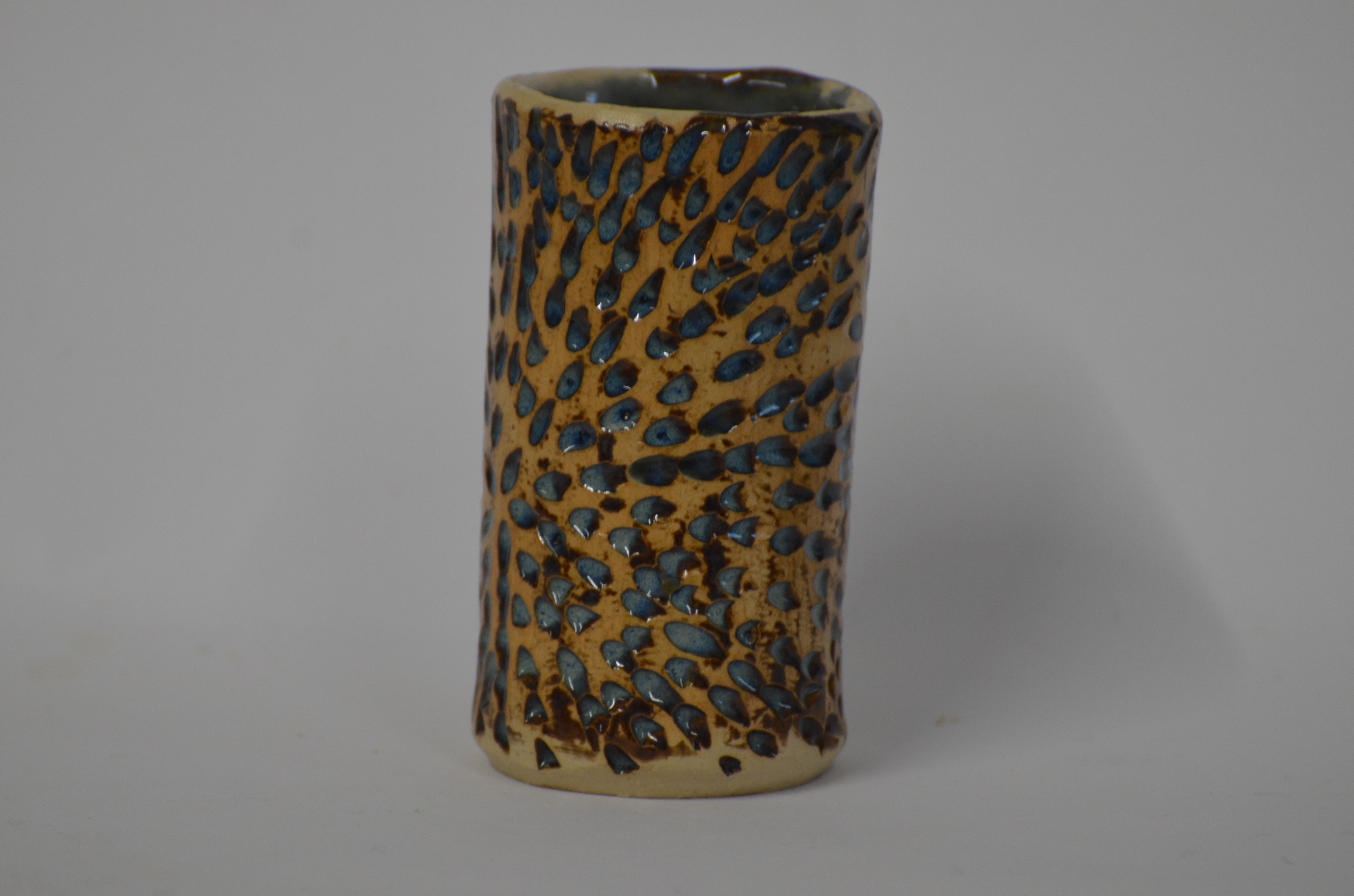 The pot was dipped in Blue Rutile Glaze which was then rubbed back to leave little pockets of glaze in the texture only. The effect was not only blue in the texture but a lovely warm hue to the rest of the pot