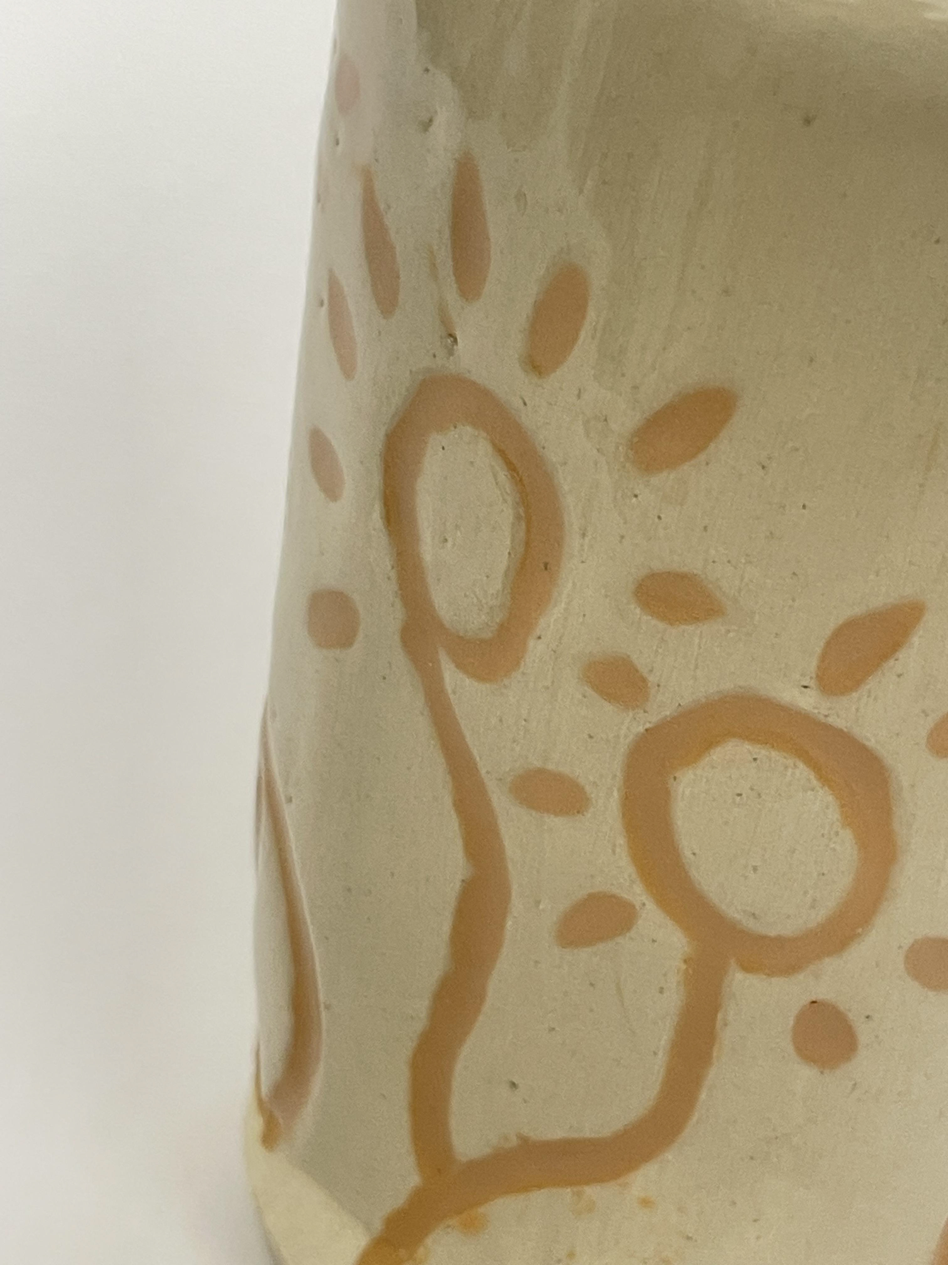 This was achieved with a technique known as Mishima. A coat of Wax resist was applied over a coat of white slip. Once dried it was carved into and then another clip applied which when rubbed back stayed only in the carved out areas.