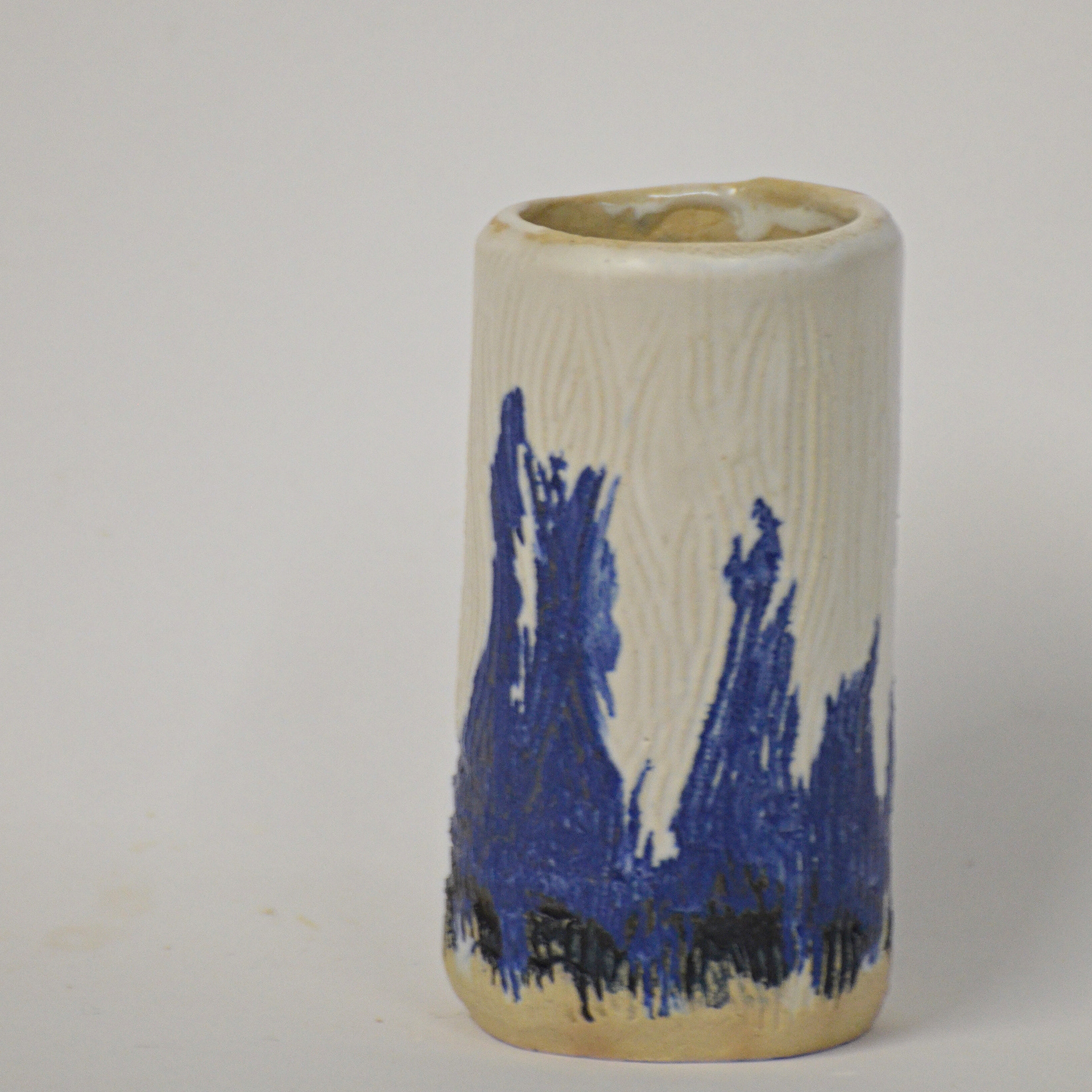Cobalt oxide highlights a very subtle texture made by scraping the surface of the pot in its greenware state. A matt white glaze over the top softens everything