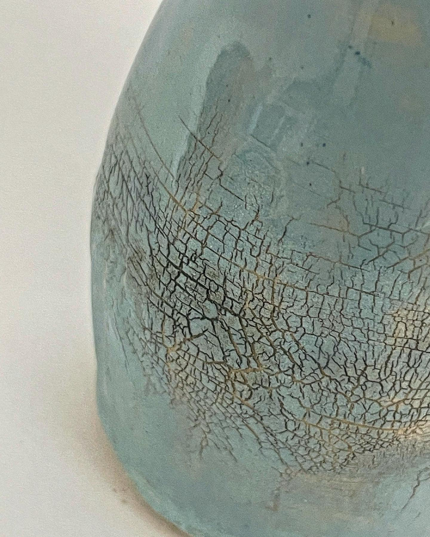 Once a slip had been applied to the pot a coating of Sodium Silicate was added. Once dried the pot was manipulted and stretched to create this cracked effect in the slip.
