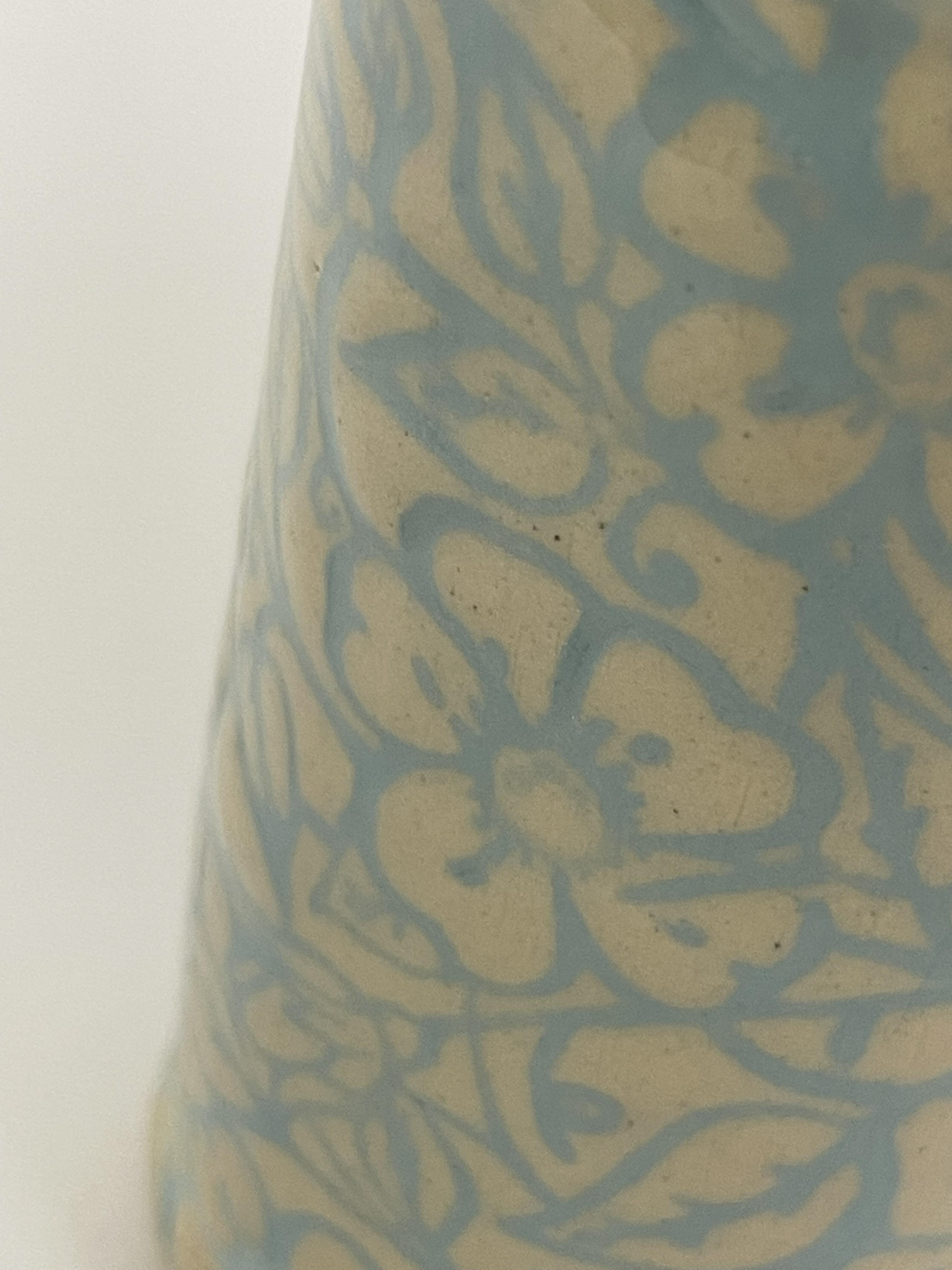 This looks similar to the Mishima technique but rather a stamp was applied and then a layer of skiip. Once dried the slip was shaved back until the imprint showed.