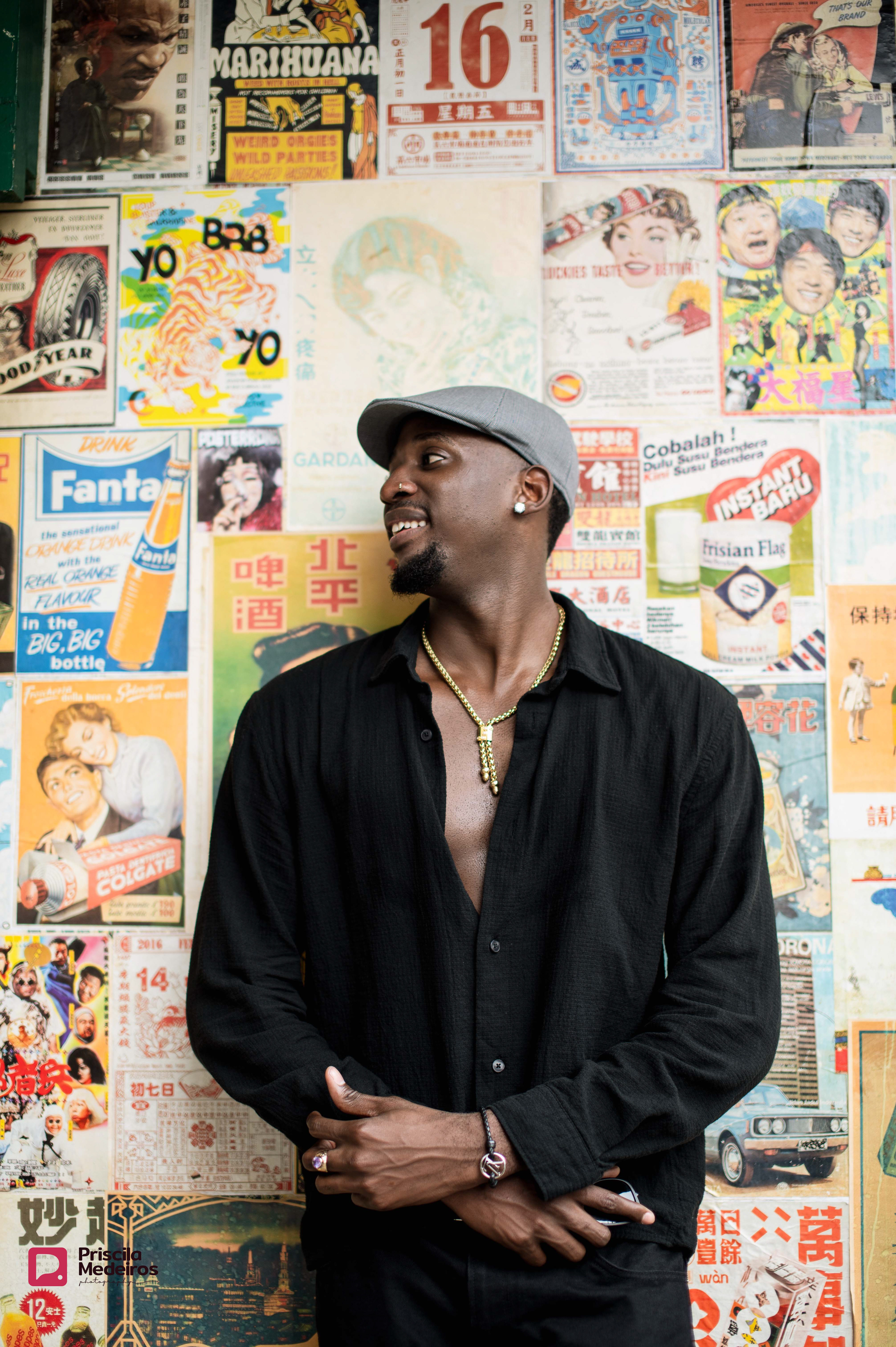 Professional travel portrait photography in Bangkok, featuring a man posing against a collage of authentic vintage Thai advertising posters.