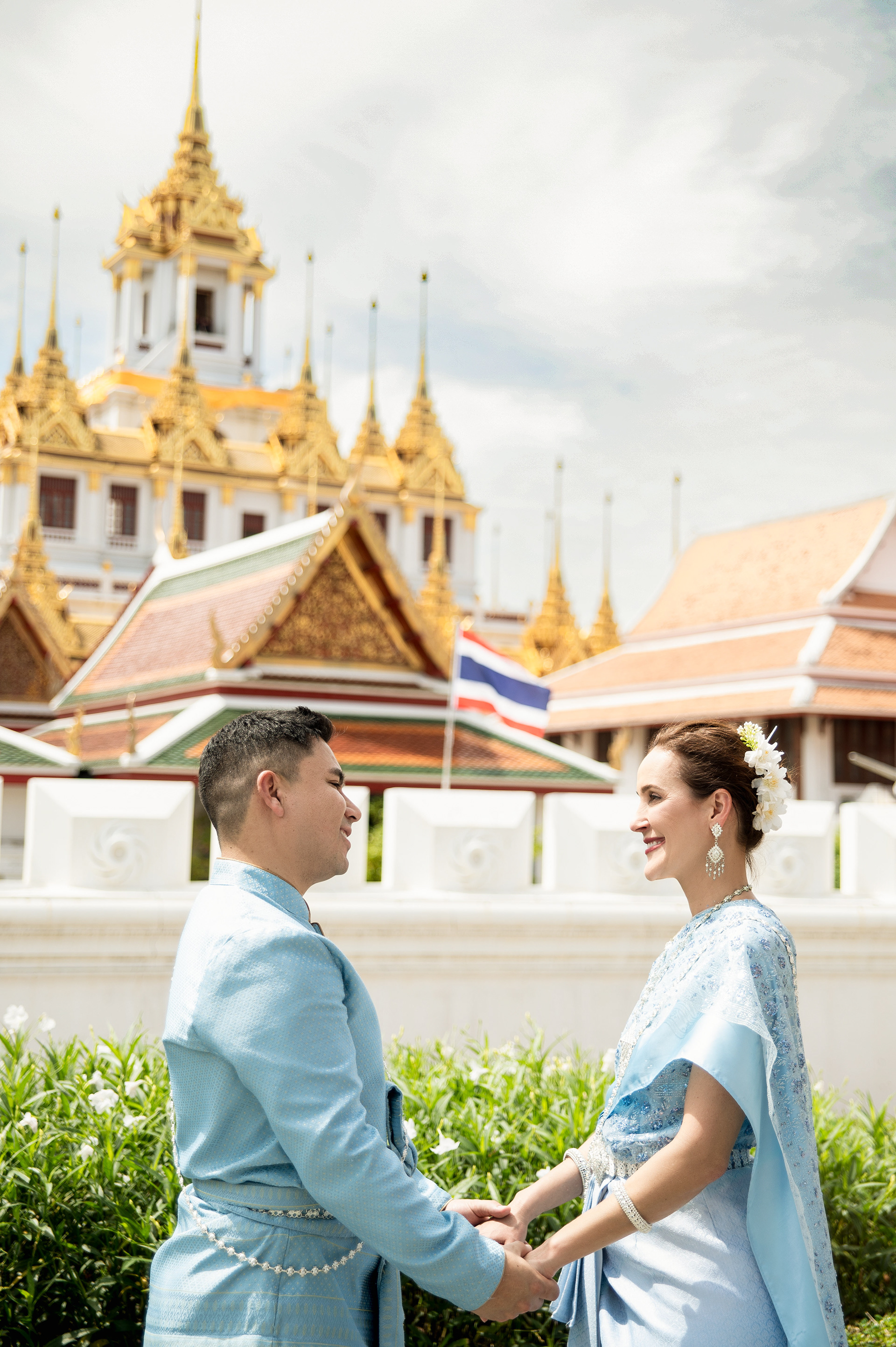 Elegant traditional Thai costume photoshoot in Bangkok featuring a gold and pink Chut Thai at Wat Ratchanatdaram temple