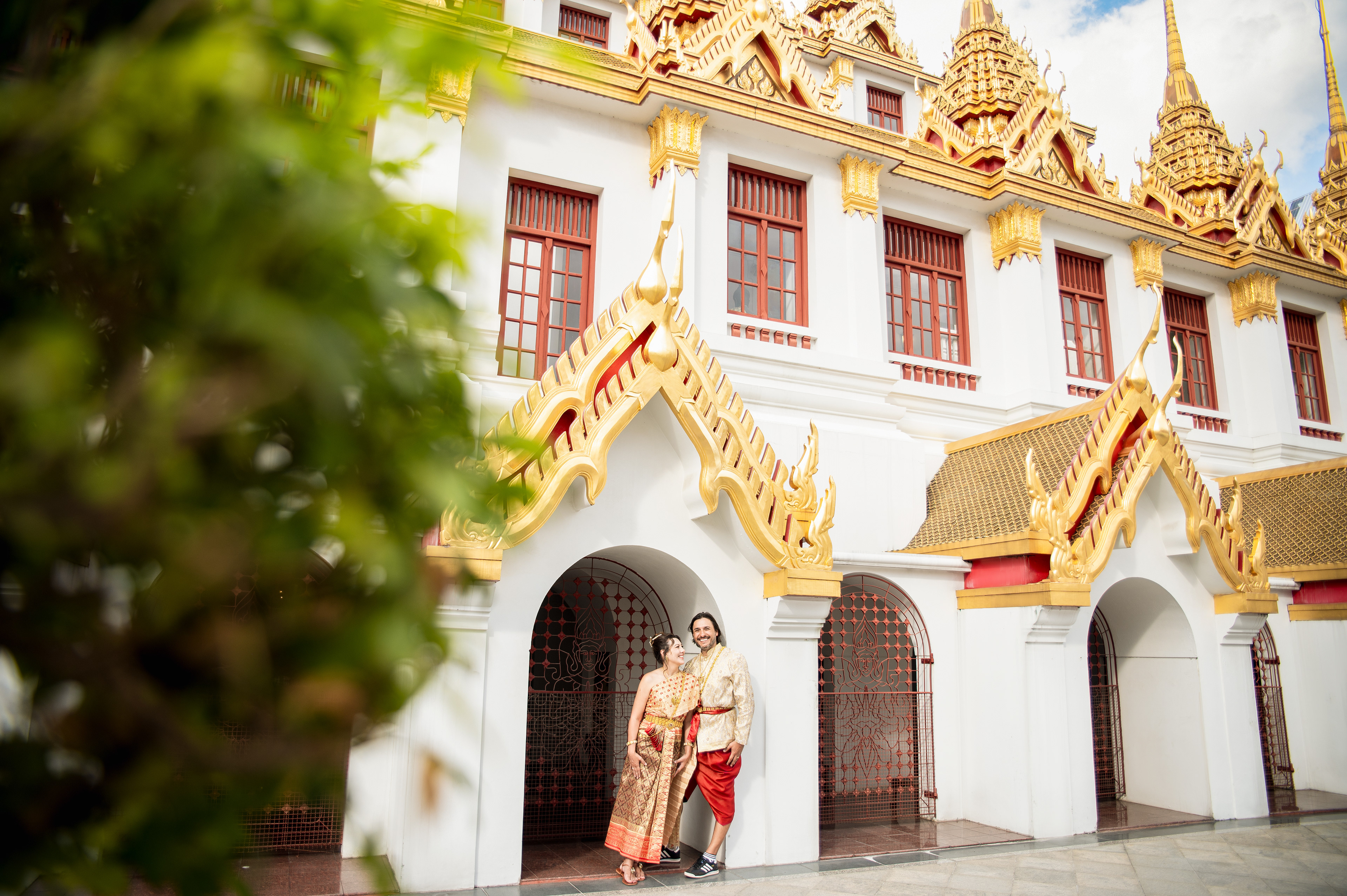 Elegant Thai costume photoshoot in Bangkok featuring a gold and pink Chut Thai at a traditional historic site.